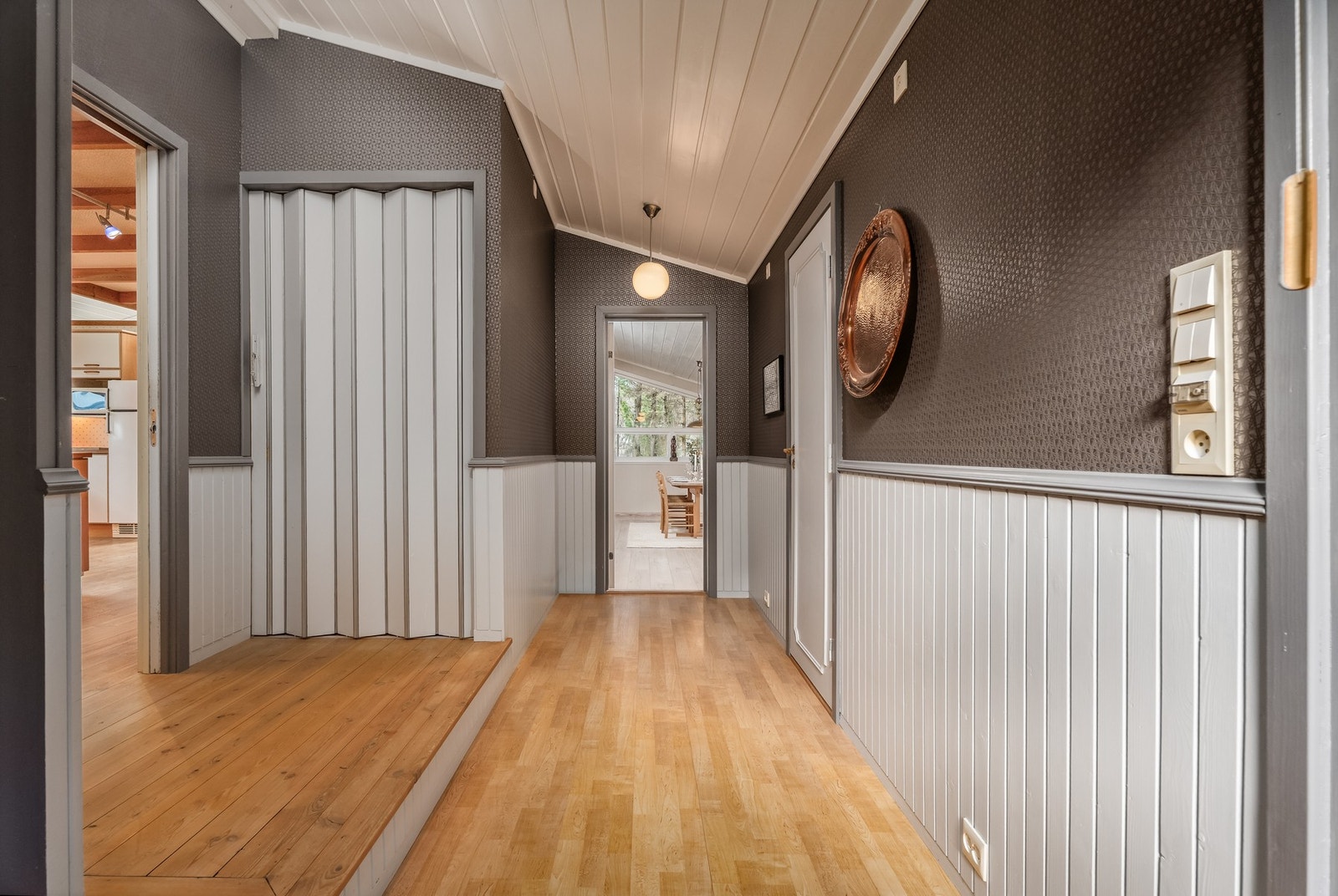 Velkommen inn i den romslige gangen vår. Døren til høyre er til en bod, foldedøren er til underetasjen og rett frem skimter du spisestuen. Galleribilde