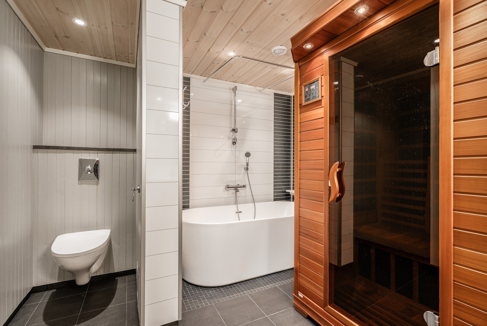 Badet i underetasjen er lekkert og innholdsrikt med vegghengt WC, flott badekar og infrarød sauna. God fornøyelse. Galleribilde