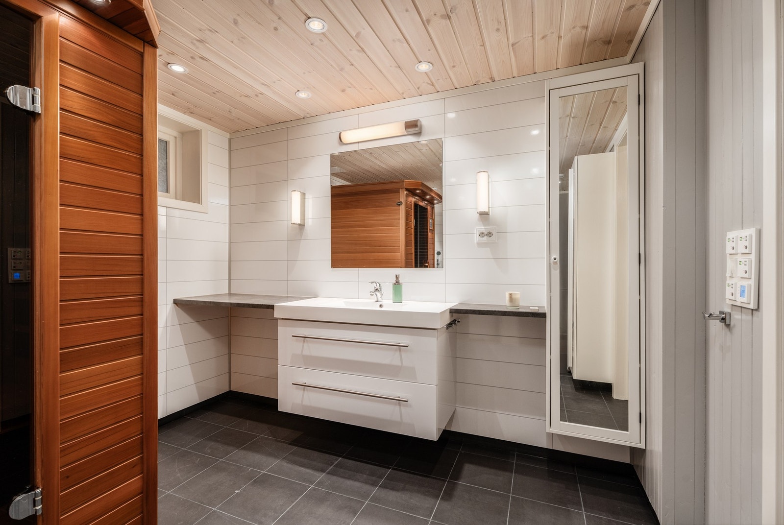 Legg merke til ordningen ved siden av servantinnredningen og høyskapet. Her har man god plass til både håndklær og alt av produkter Galleribilde