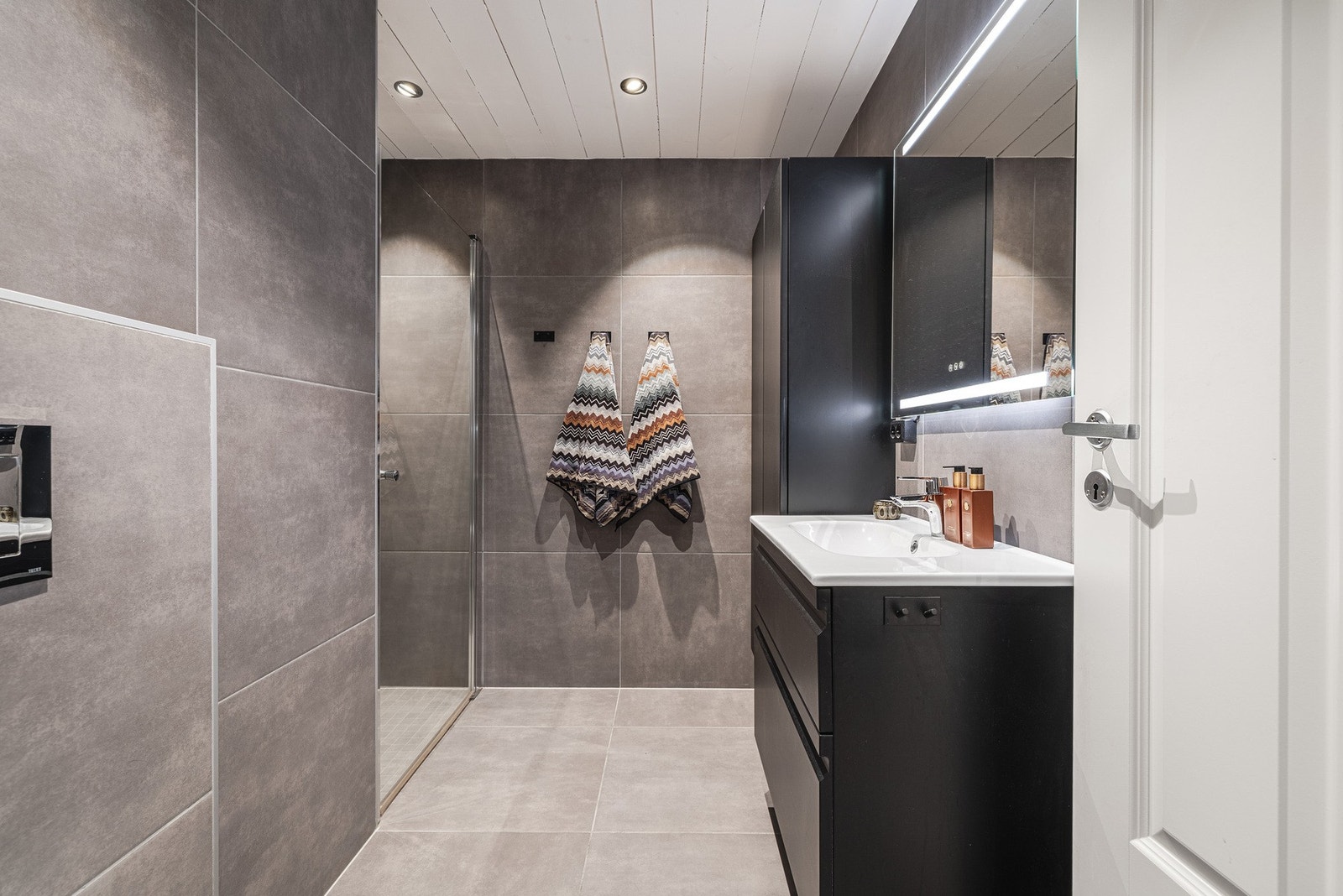 Delikat bad med romslig planløsning og stilrene fliser. Galleribilde