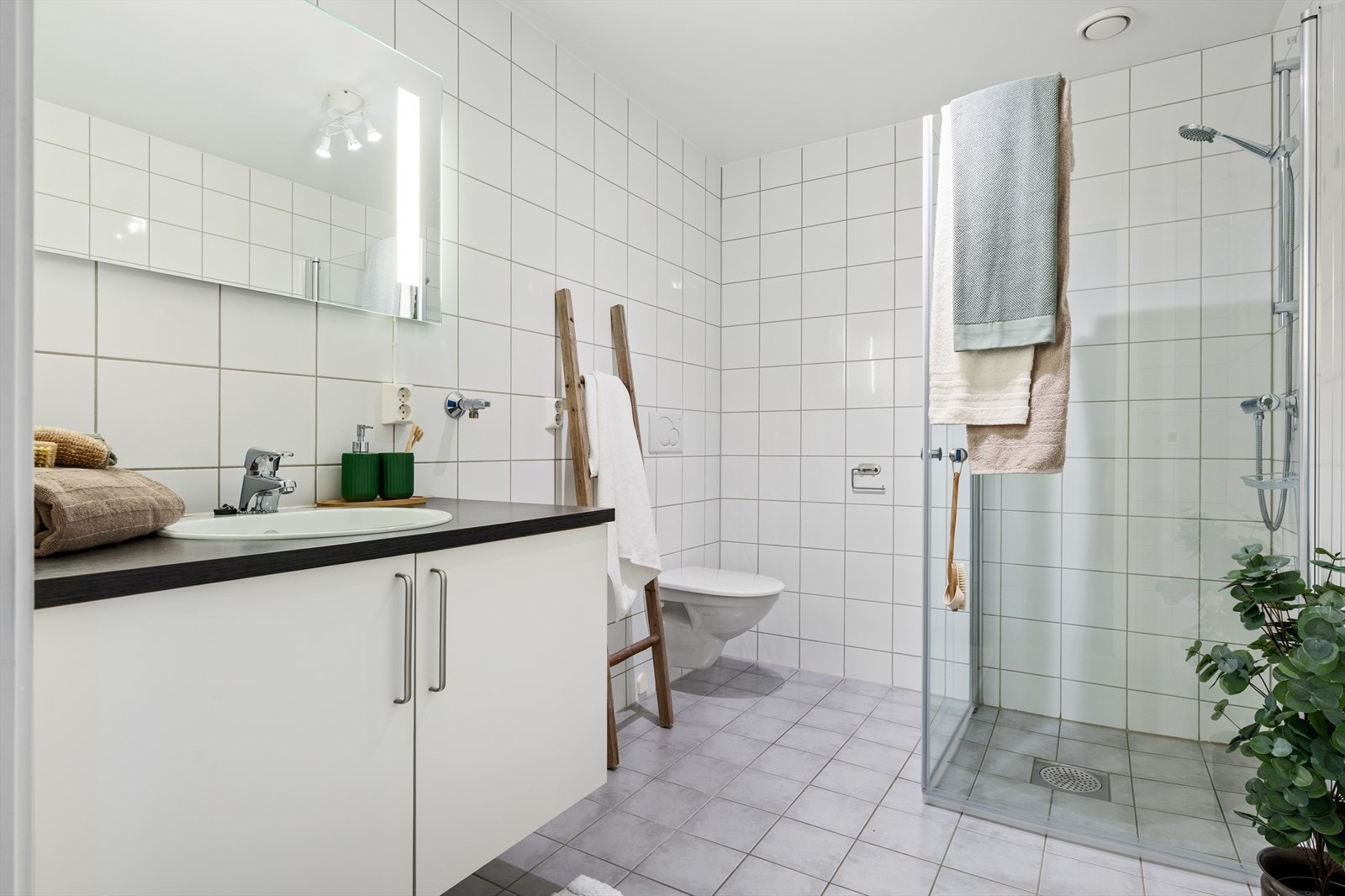 Det 5,5 kvm store badet er flislagt med behagelig gulvvarme. Galleribilde