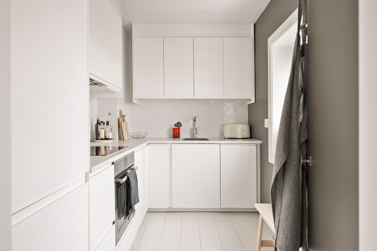 Stilren IKEA kjøkkeninnredning fra 2017/18 med laminerte skrog, slette fronter og benkeplate av laminat med nedfelt oppvaskkum. Galleribilde