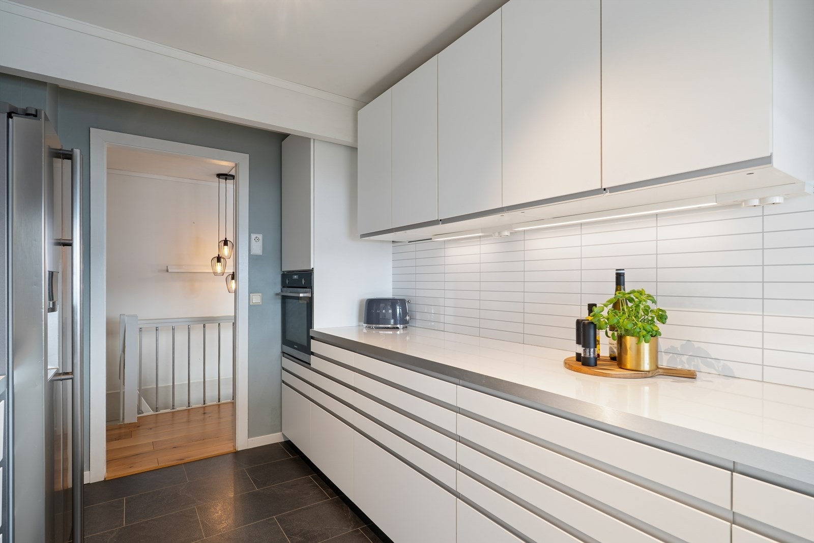 Der er montert kitchenboard mellom over- og underskap. Galleribilde