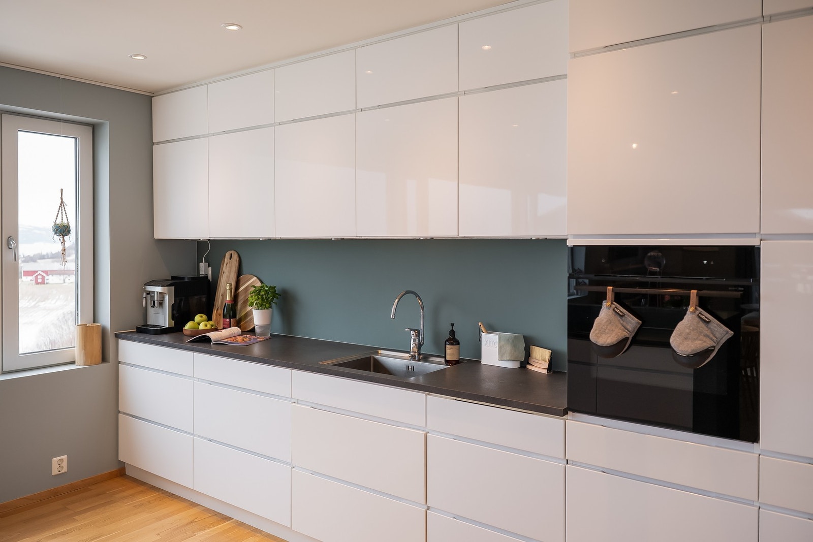 Tidløst, stilrent kjøkken med integrerte hvitevarer. Kjøkkenøy med koketopp og ventilator gjør det enkelt å holde kontakt med selskapet når man lager mat. Galleribilde