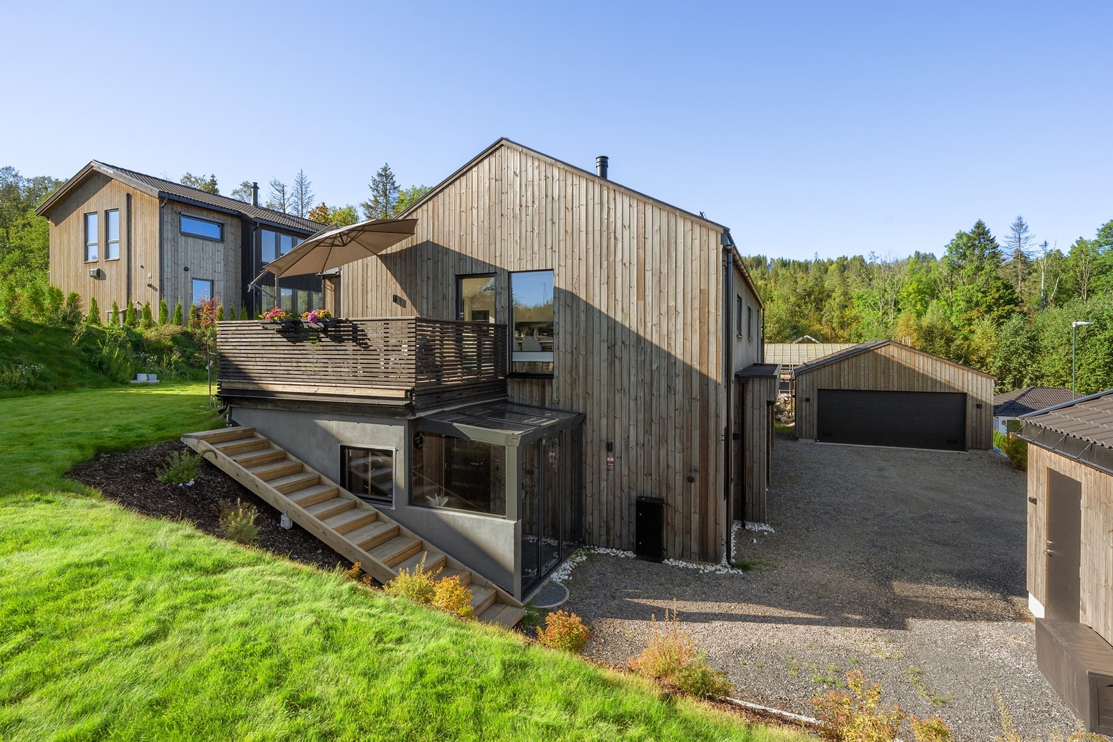 Uteområdet er vesentlig påkostet med ferdigplen, hekk, bark i skråningen m.m. Galleribilde