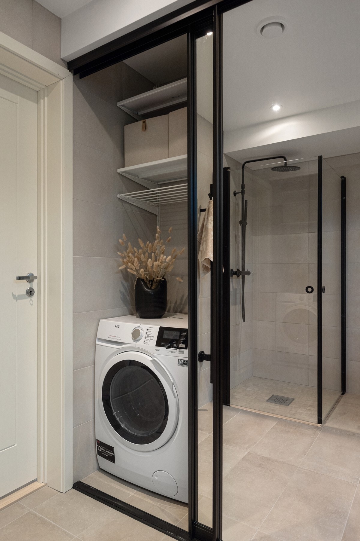 Å skjule vaskemaskin og tørketrommel bak store skyvedører er en praktisk og estetisk løsning. Galleribilde
