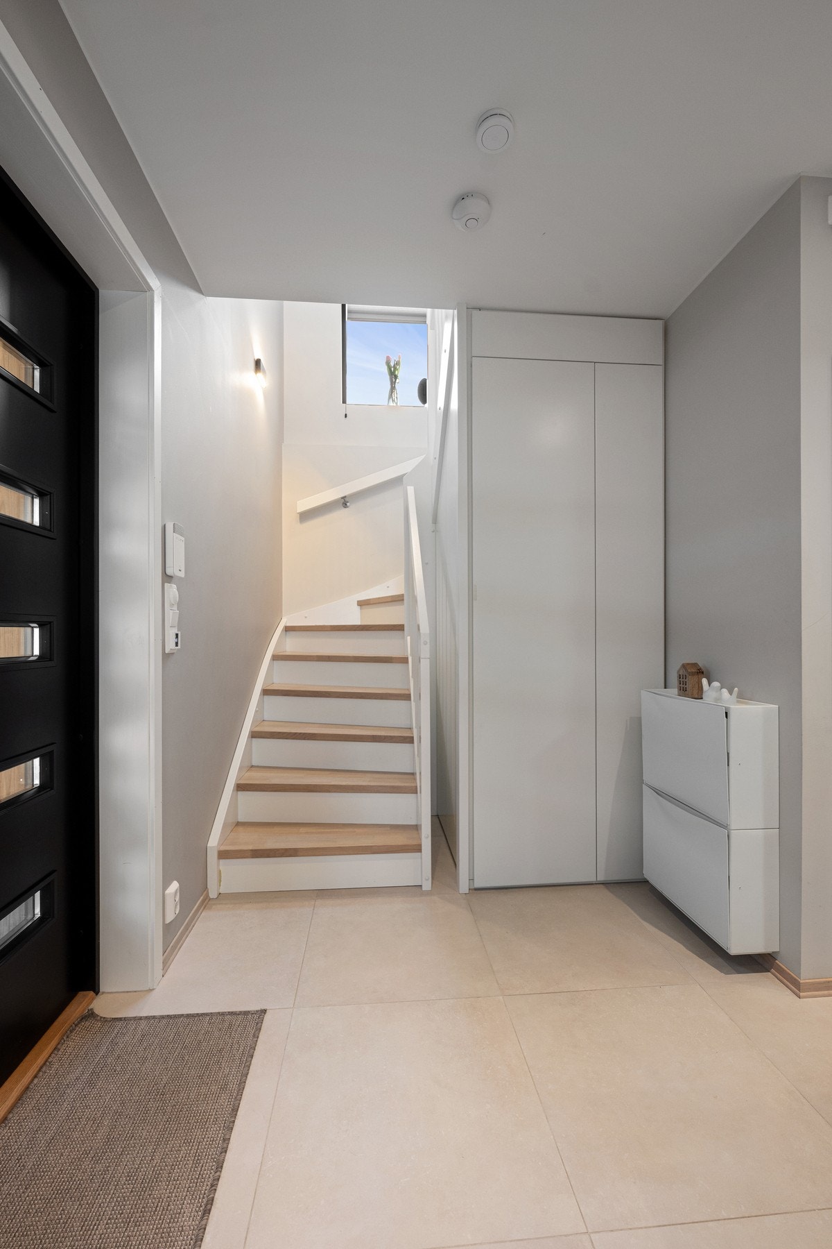 Entreen har en smart bod/oppbevaringsløsning under trappa. Galleribilde