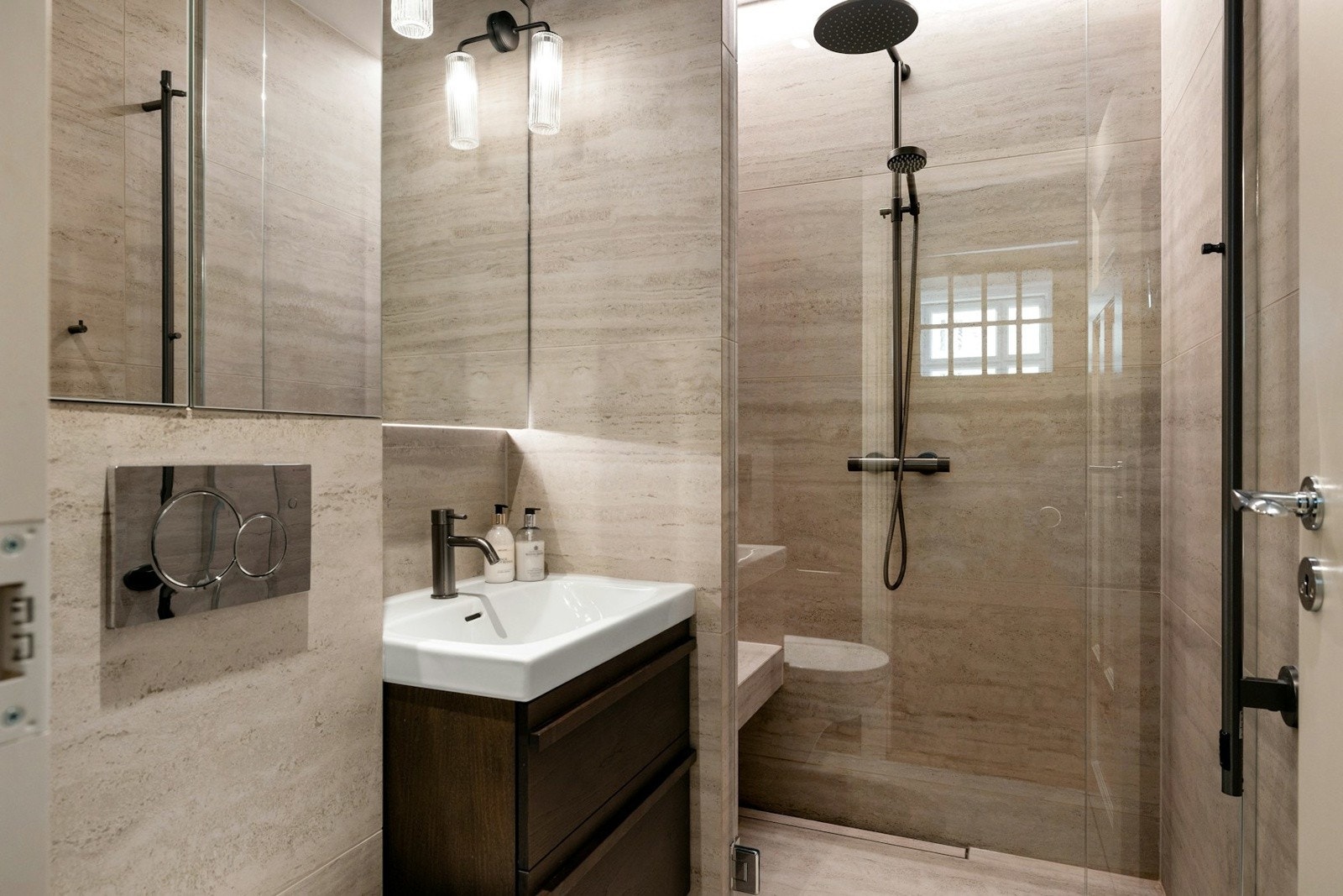 Det ene badet er utstyrt med vegghengt toalett, servant med stilrent servantskap og dusjhjørne med glassdør. Galleribilde