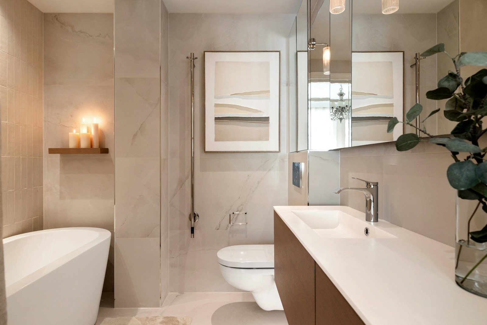 Leilighetens andre bad ligger en suite med hovedsoverommet. Badet er innredet med vegghengt toalett, en stilren servant med tilhørende servantskap i treverk, som gir god oppbevaringsplass. Galleribilde