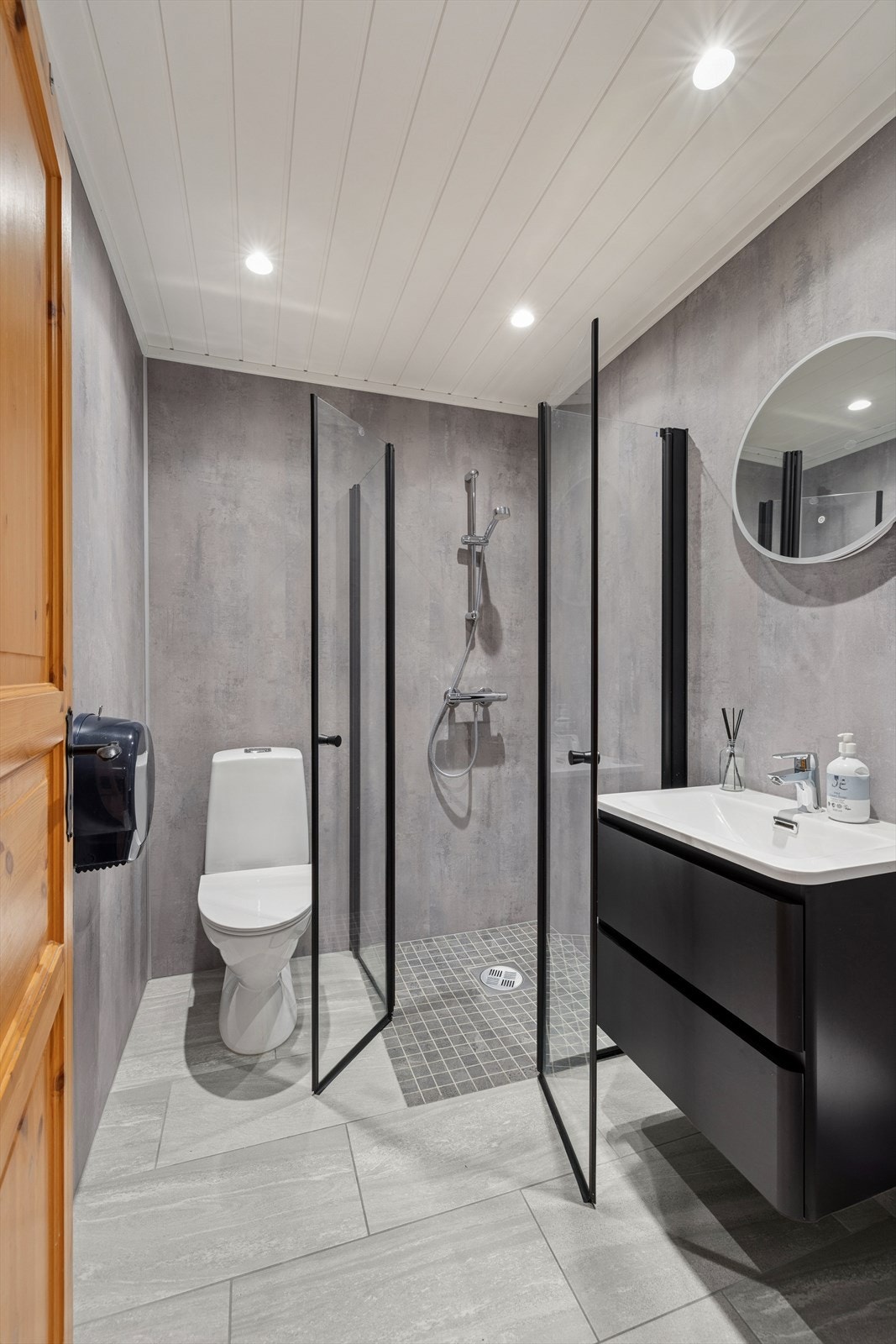 Delikat bad med flislagt gulv med gulvvarme. Veggene har våtromsplater, og himlingen er kledd med formpresset panel med innfelte lys. Galleribilde