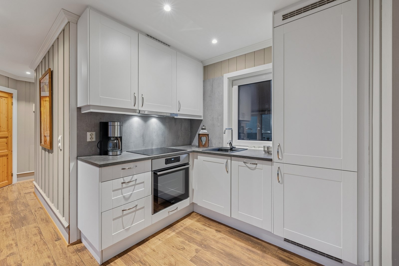 Kjøkkenet har en tidløs innredning med laminerte skrog og profilerte fronter. Benkeplaten er i laminat og er utstyrt med kjøkkenkum og kjøkkenkran. Galleribilde