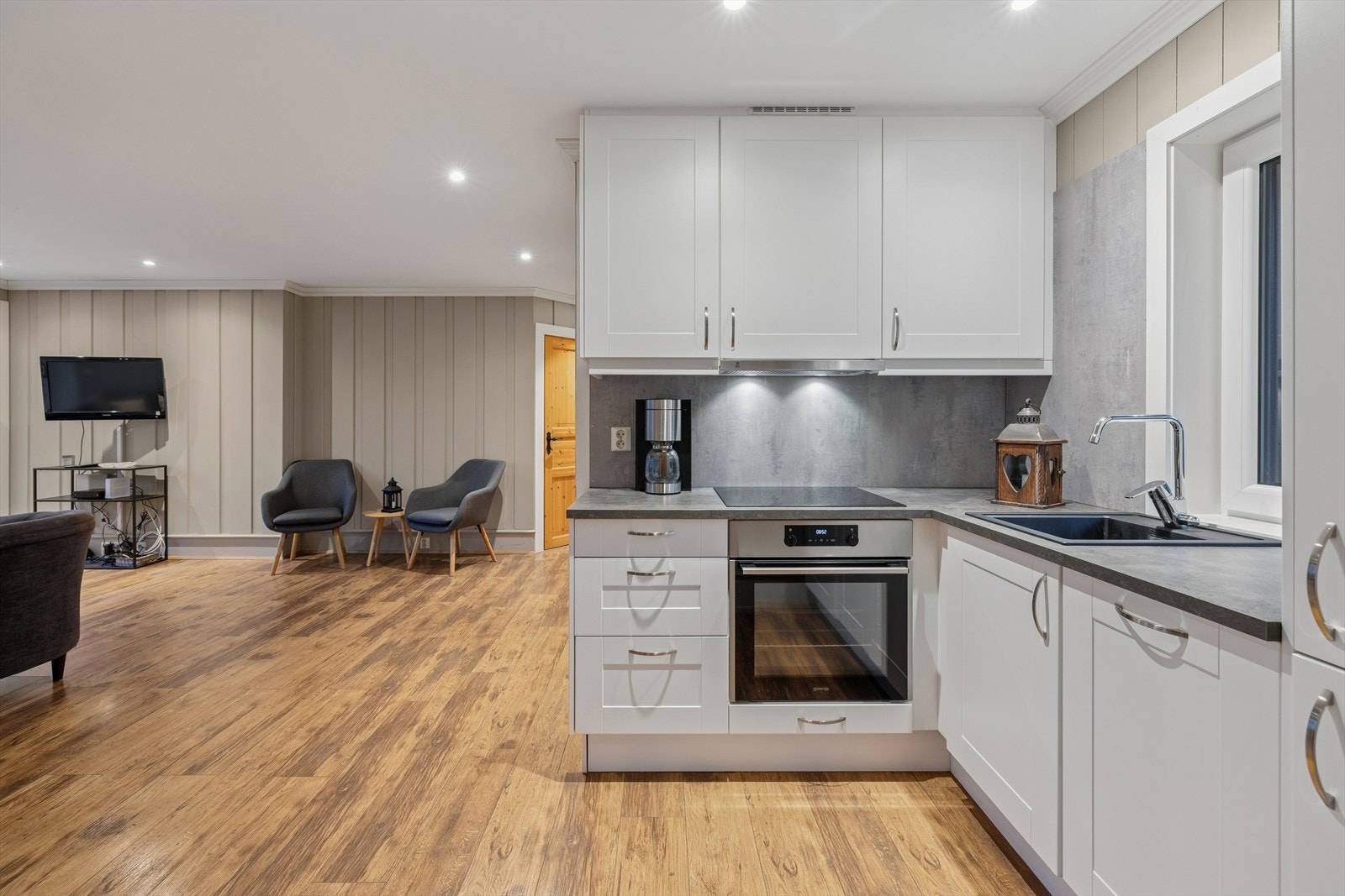 Over benkeplaten er det montert laminatplater på veggen samt belysning under overskapene. Galleribilde