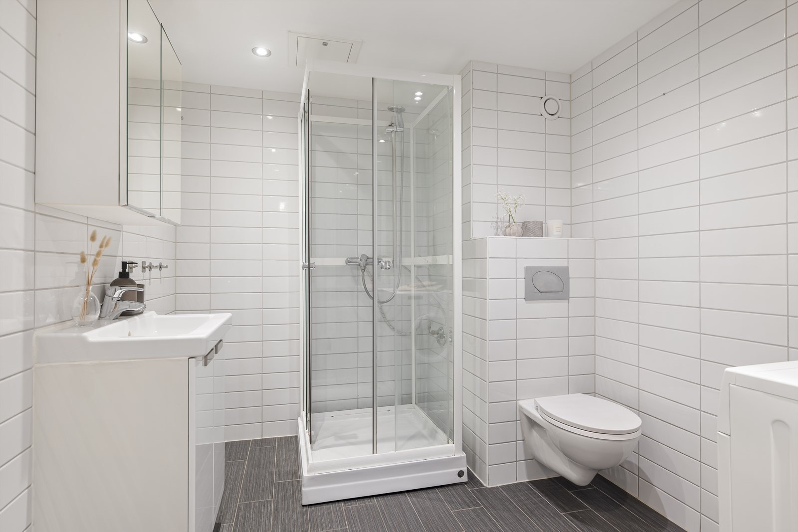 Innredningen består av benkeskap med glatte fronter. Sanitærinstallasjon med servant, klosett, dusjkabinett og opplegg for vaskemaskin. Det er mekanisk avtrekk på baderommet. Galleribilde