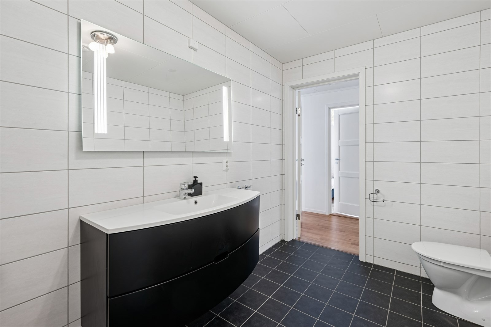 Badet er utstyrt med gulvmontert toalett og har malte plater i himlingen. Galleribilde