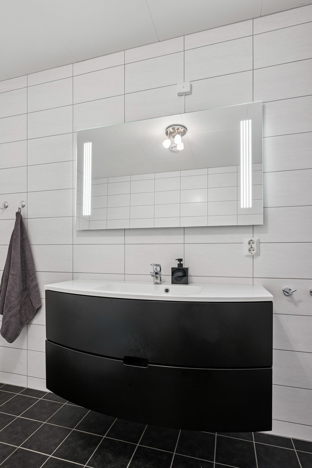 Innredningen har slette fronter, heldekkende servant og speil med integrert belysning. Galleribilde