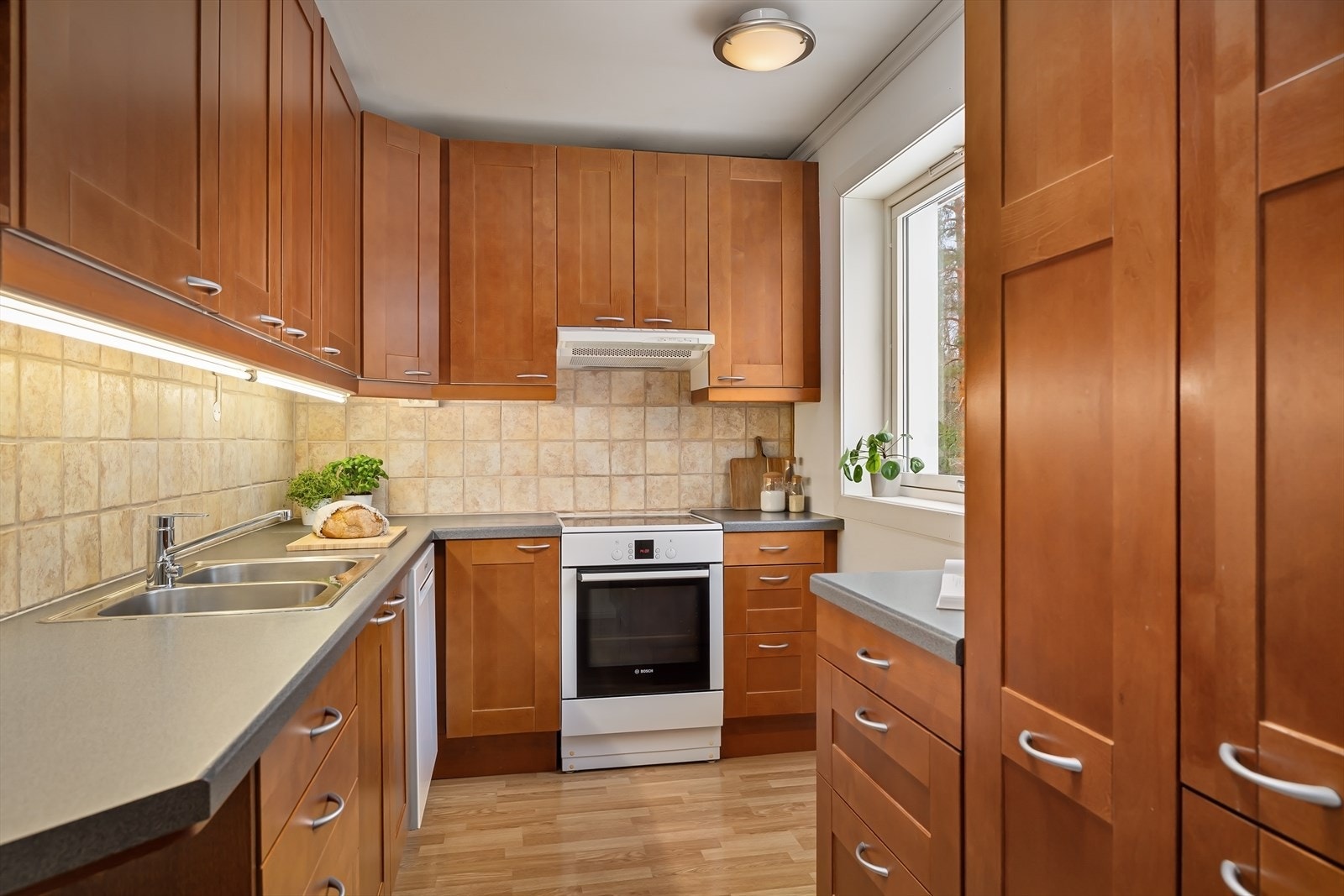 Kjøkkenet ligger adskilt fra stuen og er godt utnyttet med rikelig med både skap og benkeplass. Galleribilde