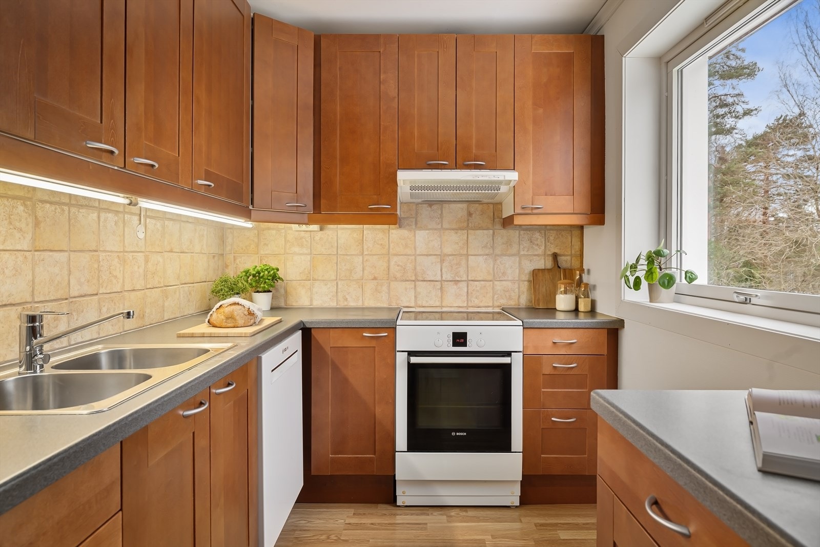 Kjøkkenet er innredet med profilerte fronter, laminat benkeplate og flislagt backsplash. Galleribilde