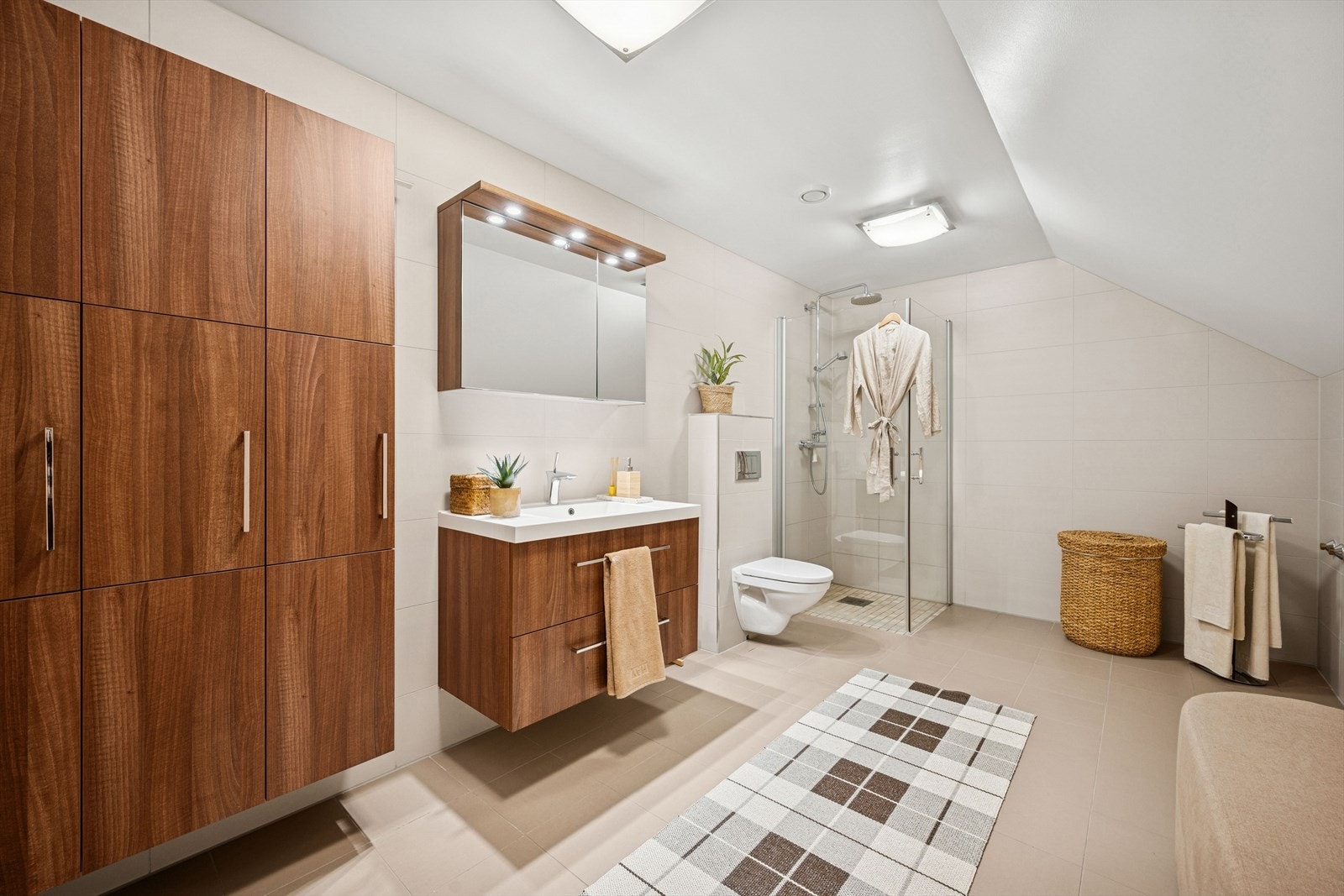 Badet i 2. etasje er flislagt og innredet med servant, vegghengt toalett og dusjløsning. Opplegg for baderkar. Galleribilde