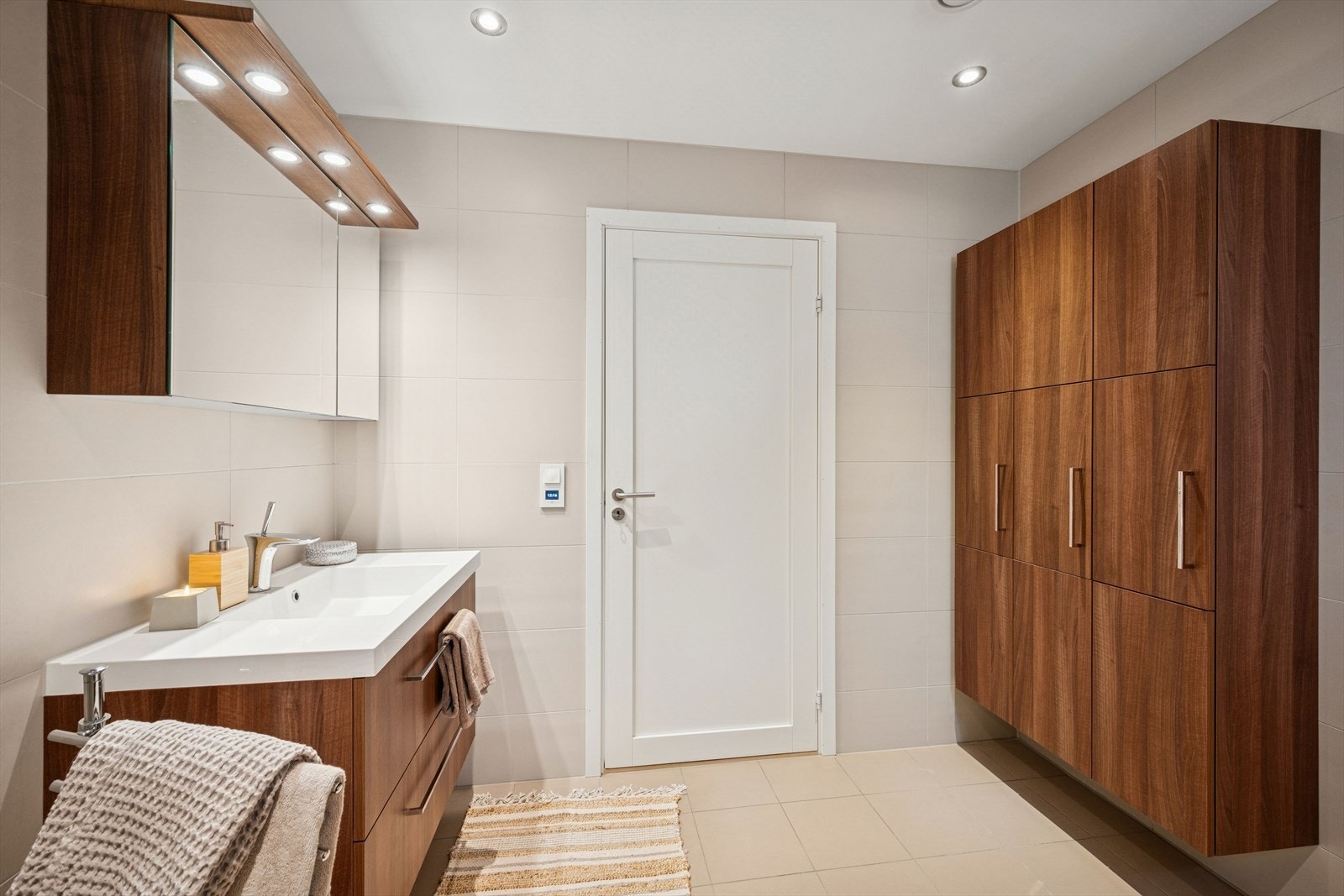 Badet er flislagt og fremstår med moderne innredning. Rommet er utstyrt med vegghengt toalett, servant med møbel og dusjløsning. Elektriske varmekabler i gulv gir god komfort. Galleribilde