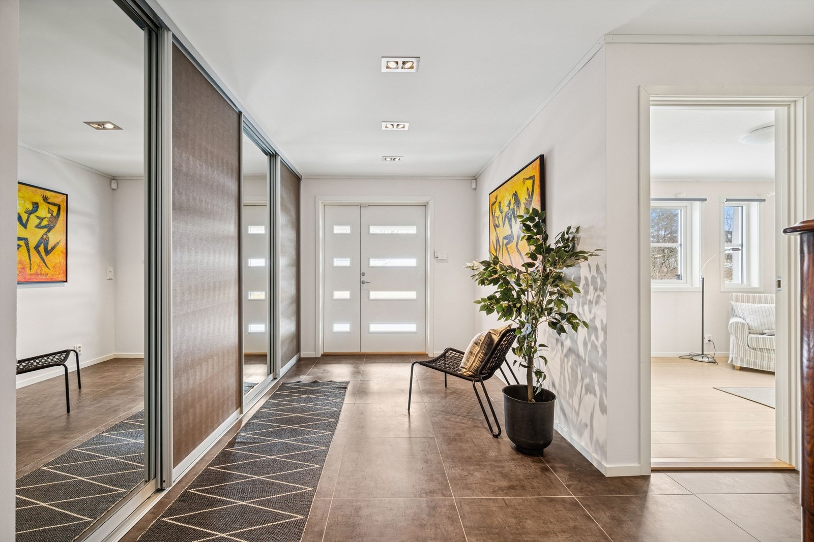 Boligen ønskes velkommen via en romslig entré med flislagt gulv og skyvedørsgarderobe som gir gode oppbevaringsløsninger. Galleribilde