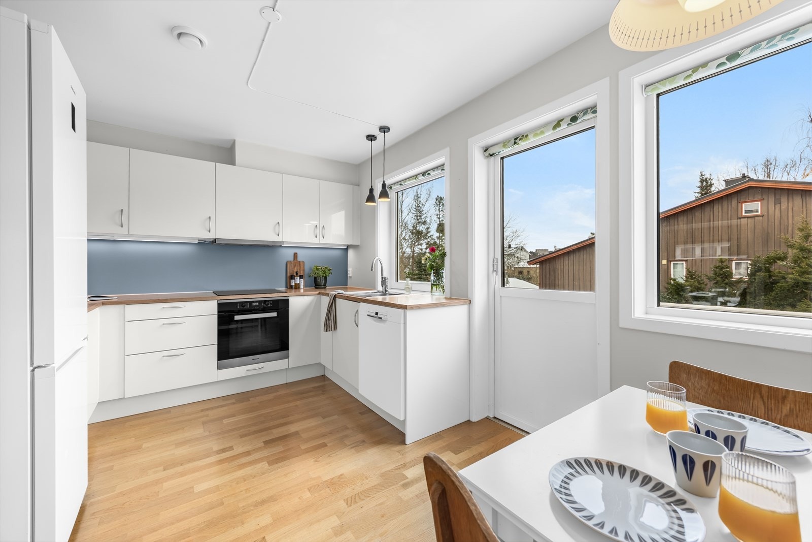 Store vinduer gir rikelig med naturlig lys til kjøkkenet, som også har utgang til balkong. Galleribilde