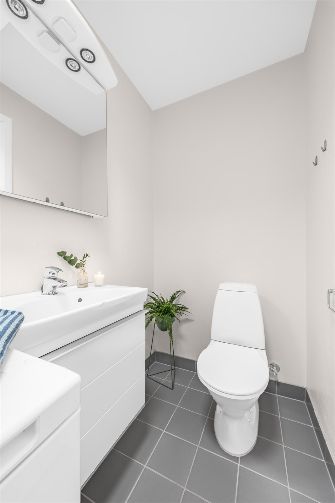 Baderommet i hybelen har flislagt gulv med varmekabler, malte veggplater med flisfelt i dusjsonen samt malt himling. Galleribilde