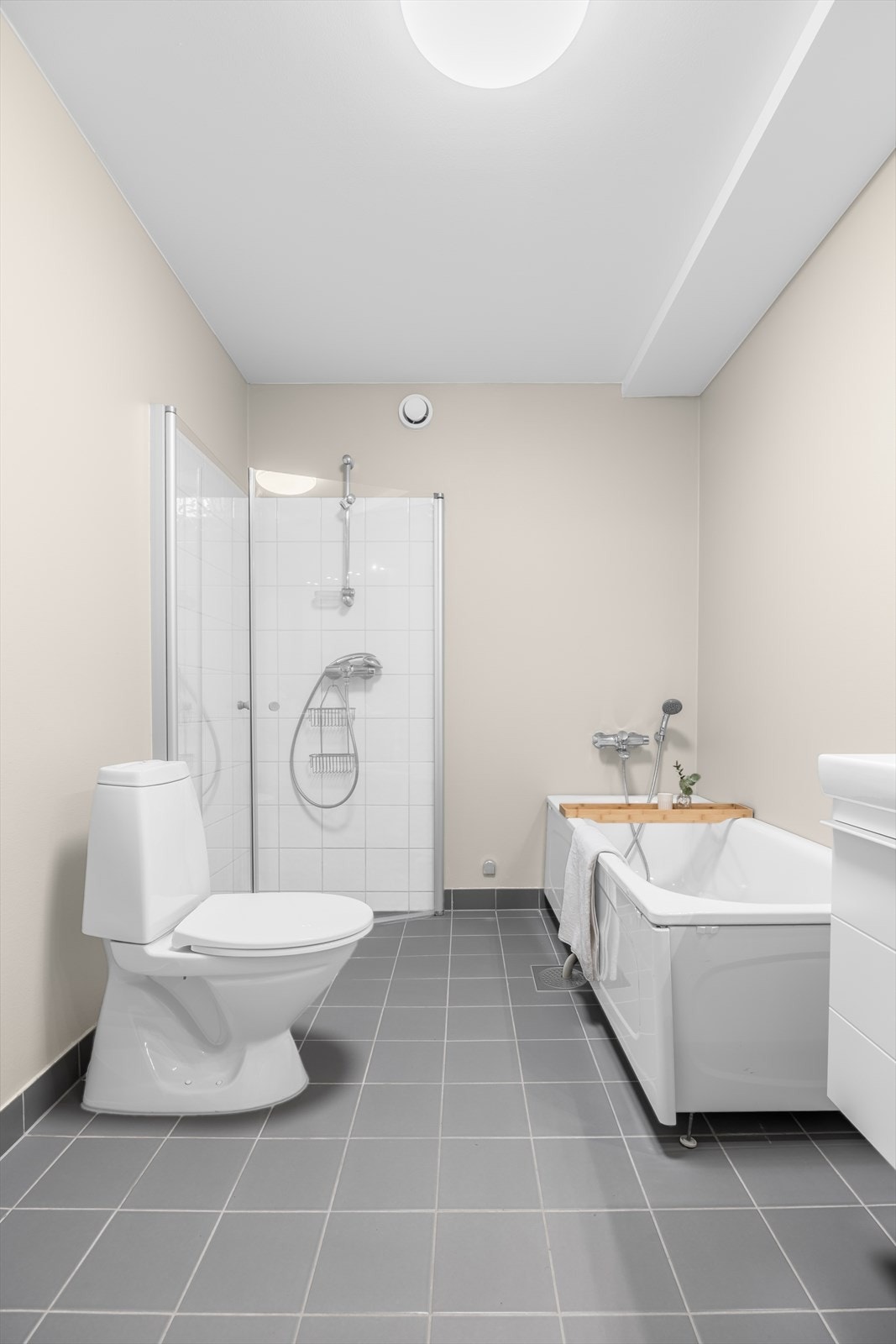 Badet er utstyrt med toalett, badekar, dusjhjørne og nedfelt servant i baderomsmøbel. Det er opplegg for vaskemaskin. Galleribilde