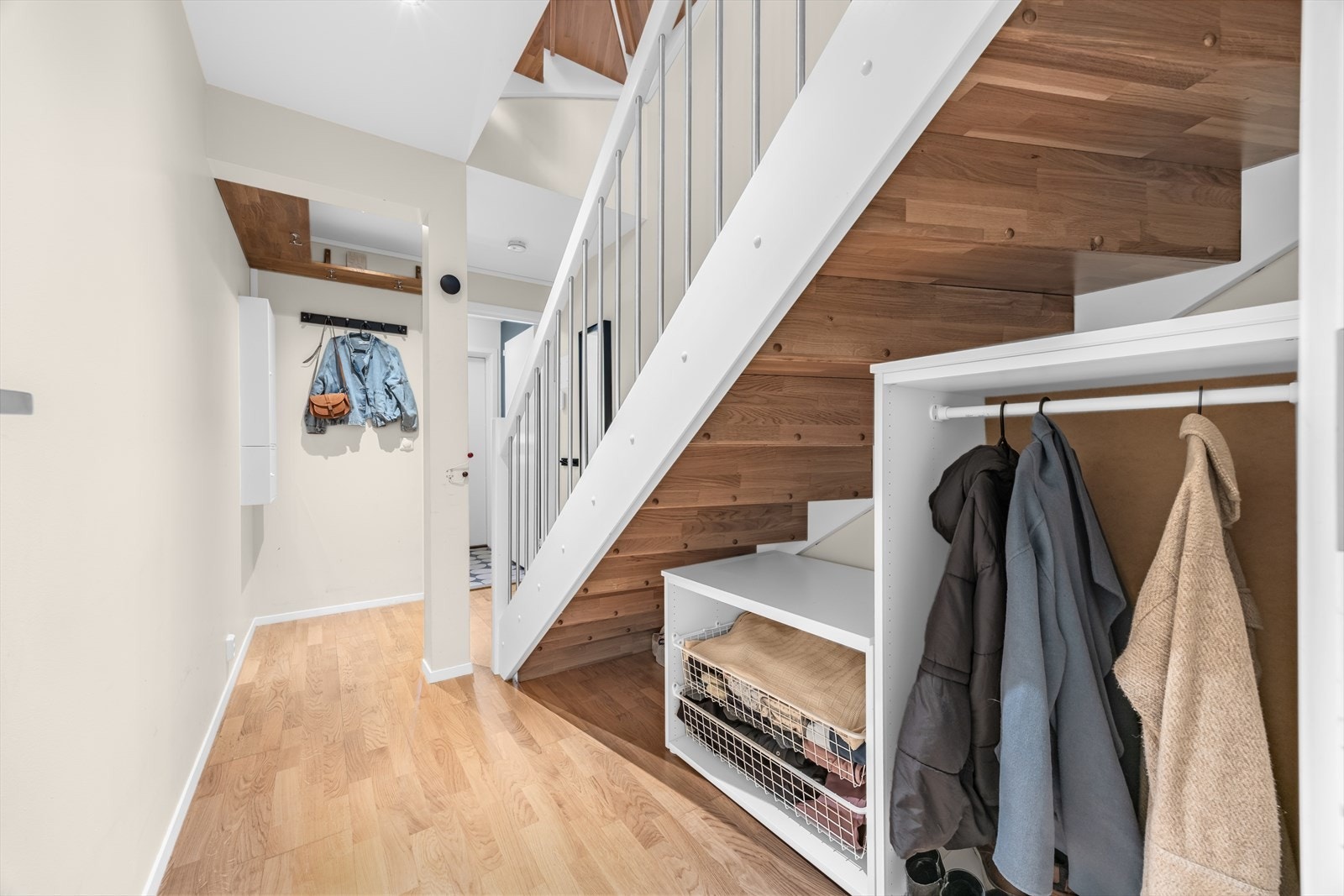Garderobeløsning under trappen gir praktisk oppbevaring i entréen. Galleribilde