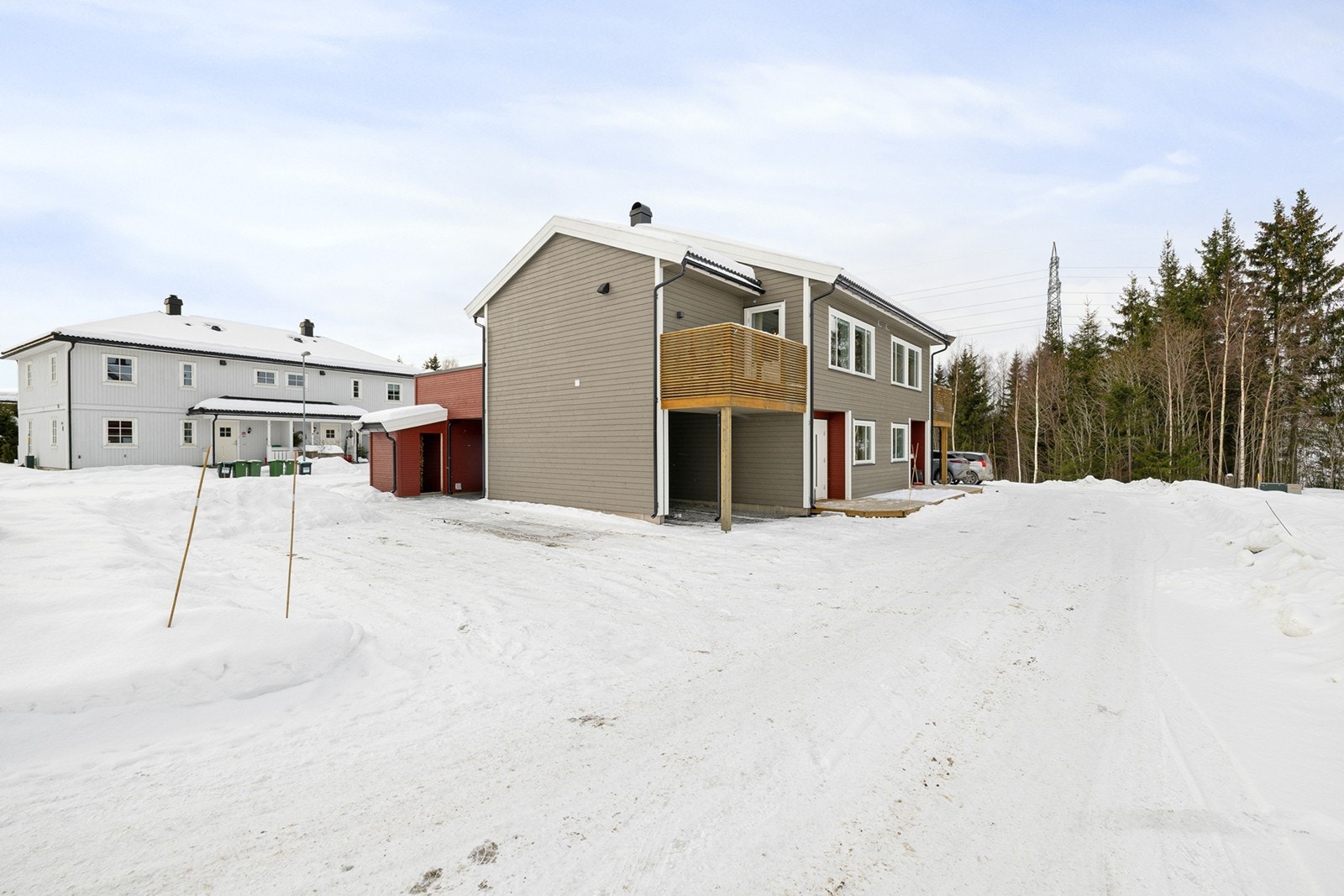 Parkering i carport med bod i bakkant som følger boligen. Det er montert Easee ladeboks. Galleribilde