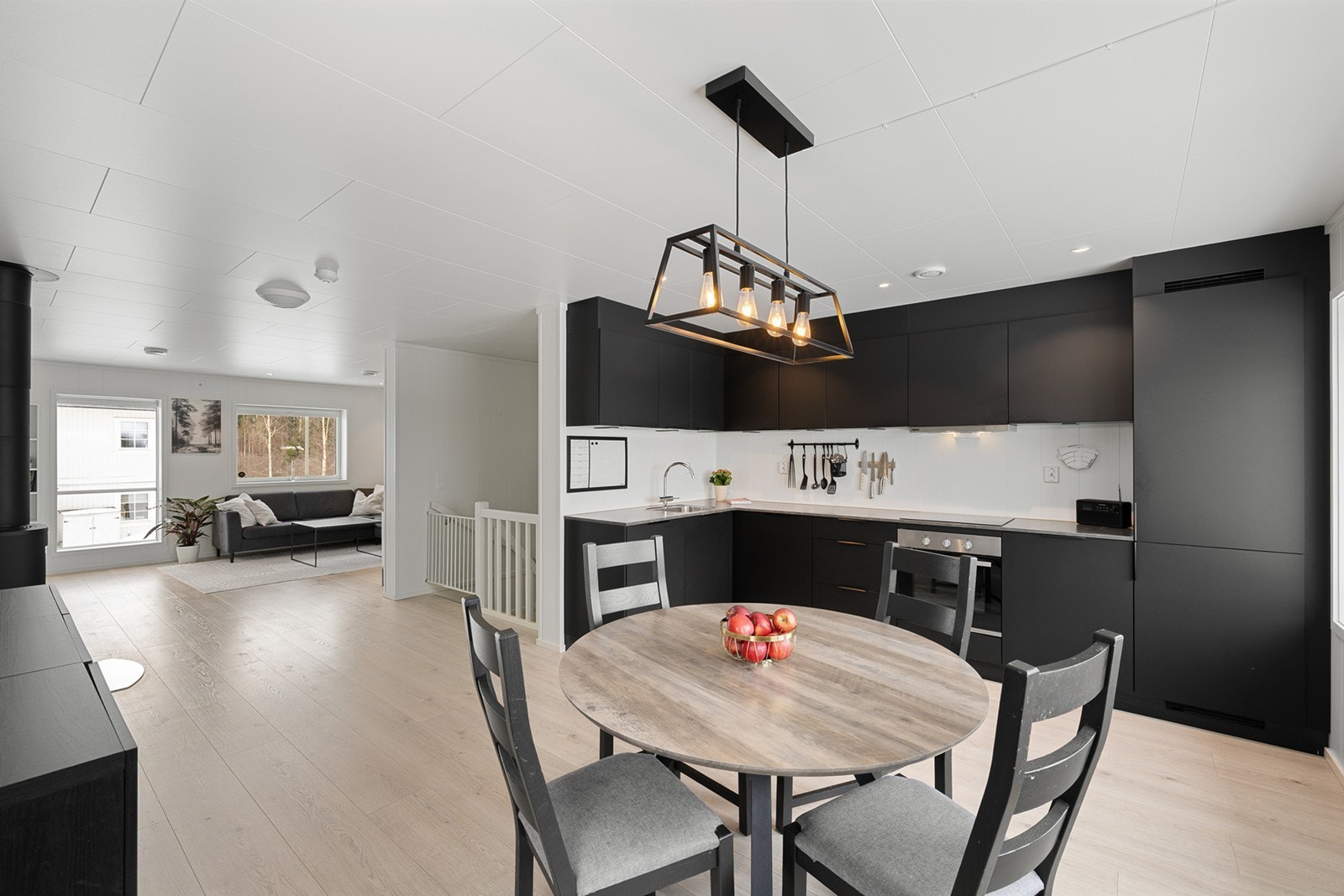 Lys og innbydende åpen kjøkken- og stueløsning med gjennomgående vindusflater på begge sider. Galleribilde