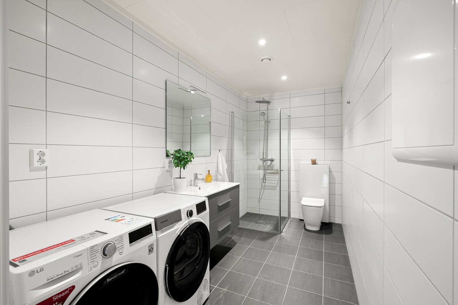 Flislagt og delikat bad med gulvvarme som gir en behagelig og lun komfort året rundt. Lyse fliser på vegger og mørkere fliser på gulv, noe som gir et moderne og stilrent uttrykk. Galleribilde