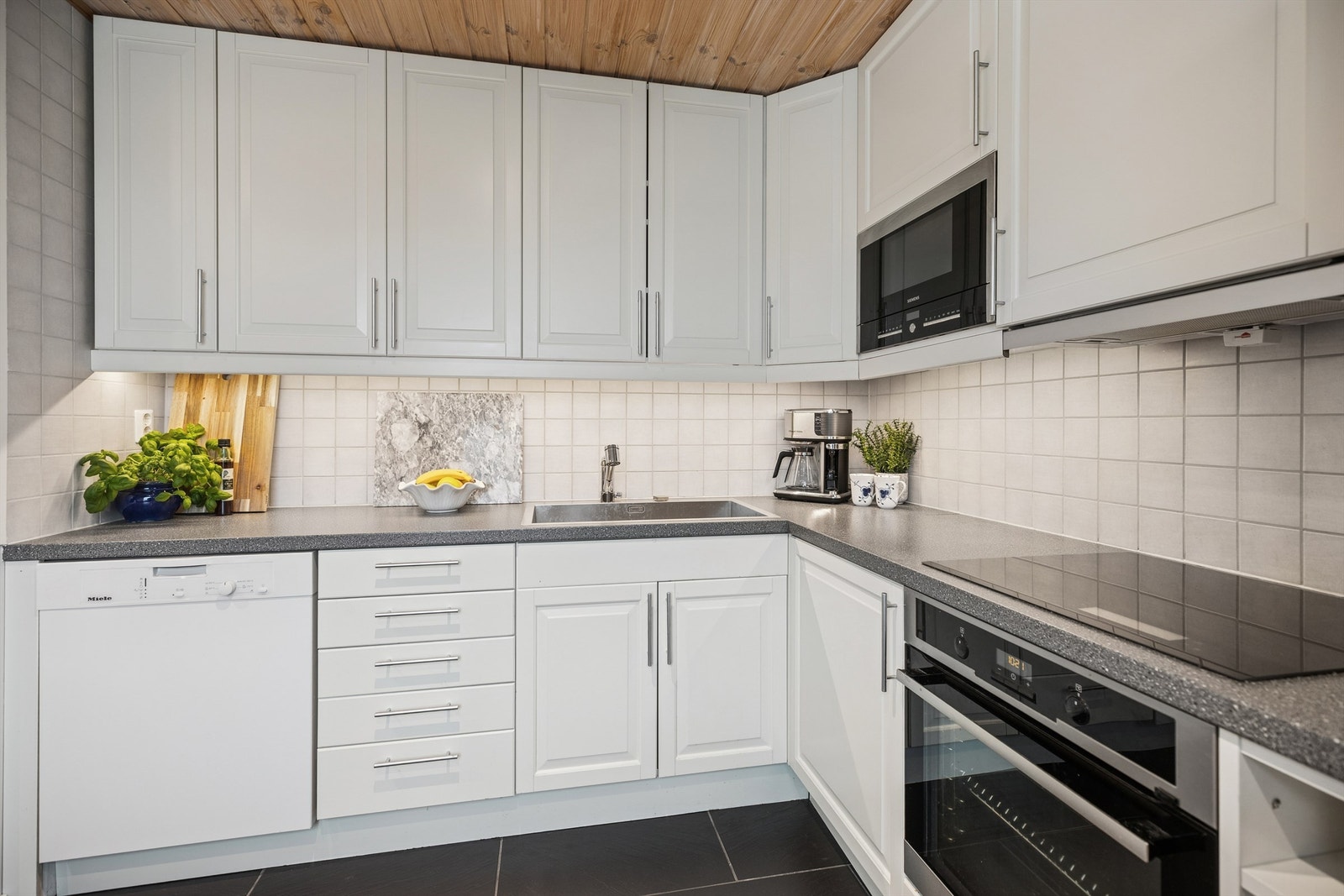 Epoc kjøkkeninnredning fra 2014 med lyse, profilerte fronter. Her er det rikelig med benkeplass, samt gode oppbevaringsmuligheter i over- og underskap Galleribilde