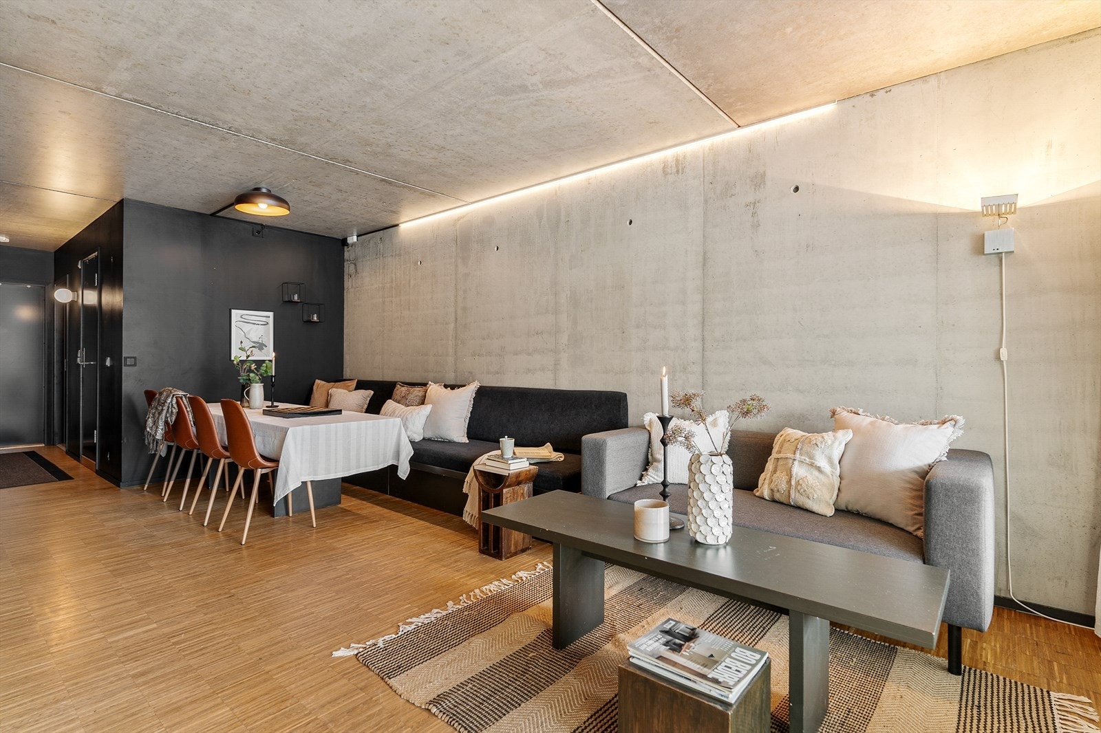 De rå betongflatene i tak og på vegger gir leiligheten en tøff og industriell karakter. Galleribilde