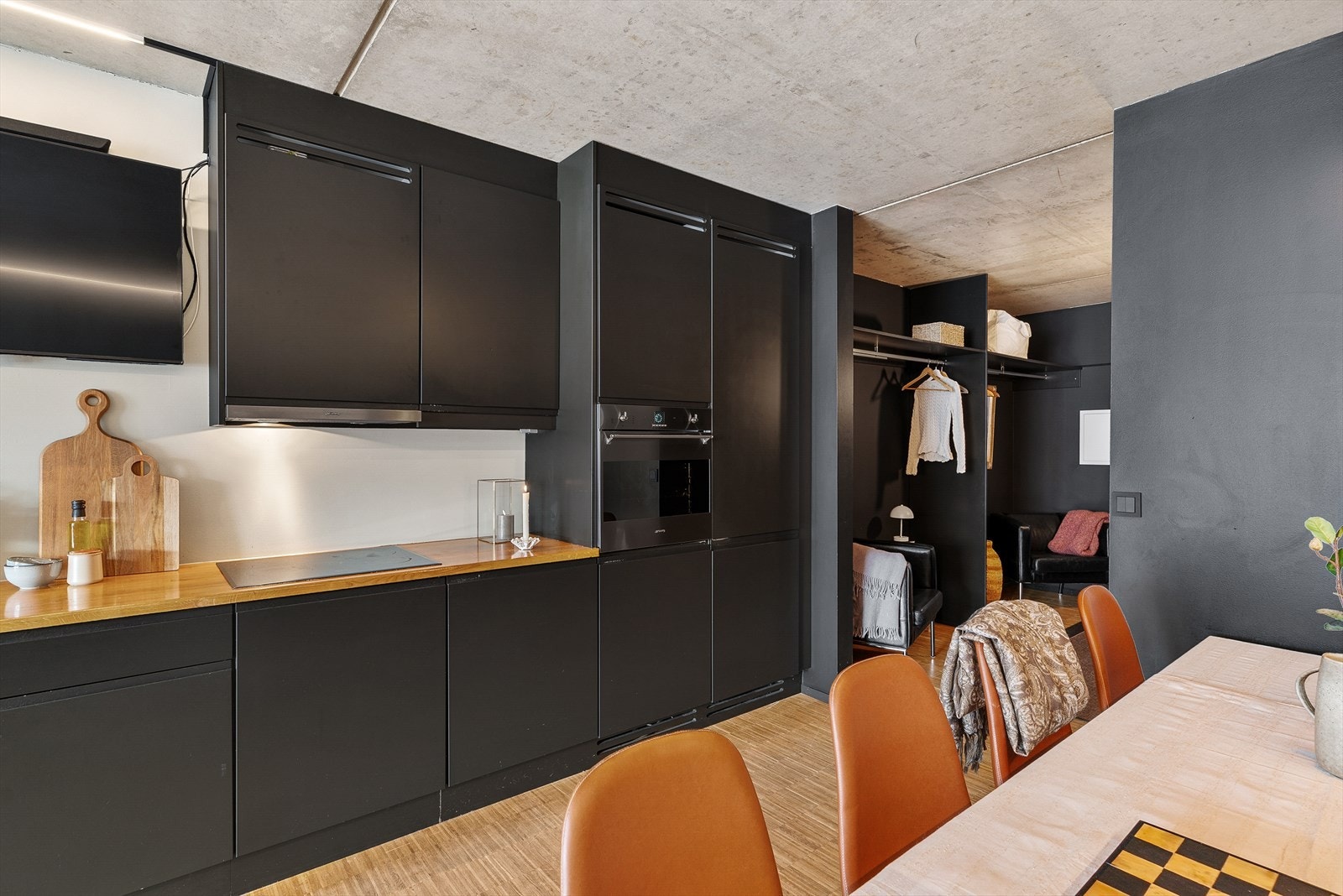 Kjøkkeninnredningen har glatte, mørke fronter og en solid benkeplate i heltre. Galleribilde