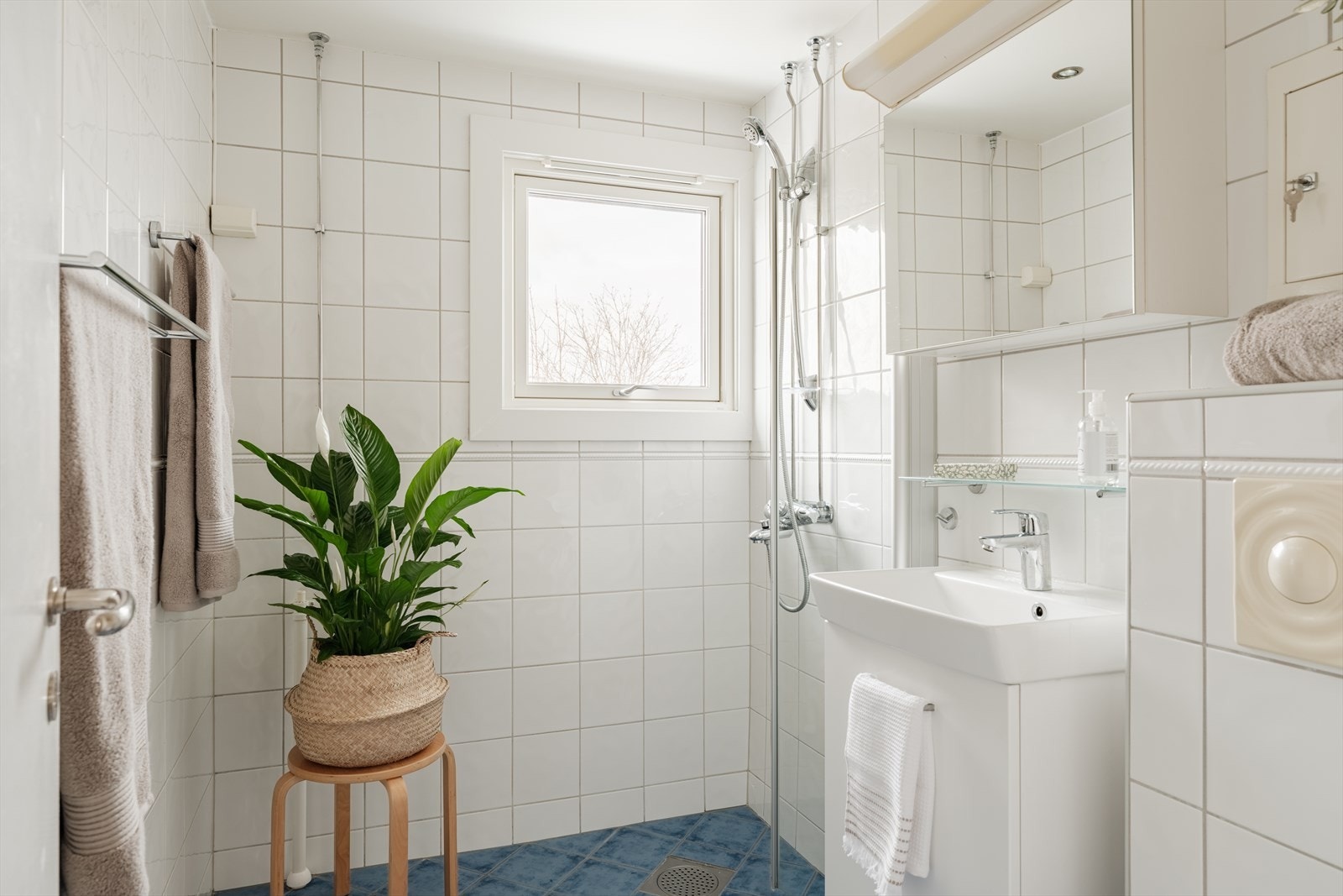 De store vindusflatene gir gode lysforhold i rommet. Det er etablert egen dusjsone og baderomsinnredning med oppbevaring i skap og speil Galleribilde