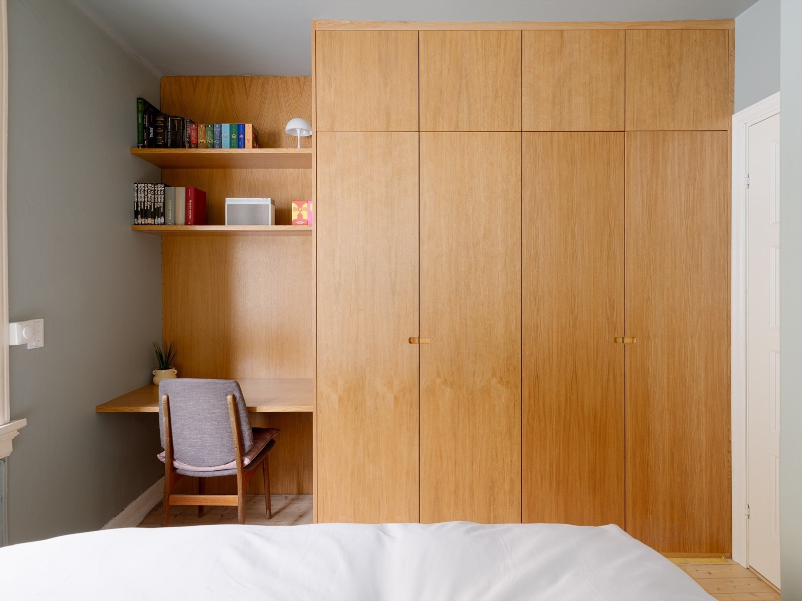 Spesialbygget garderobeskap i nisje, med skrivebordsløsning i lik stil med kjøkkenet. Galleribilde