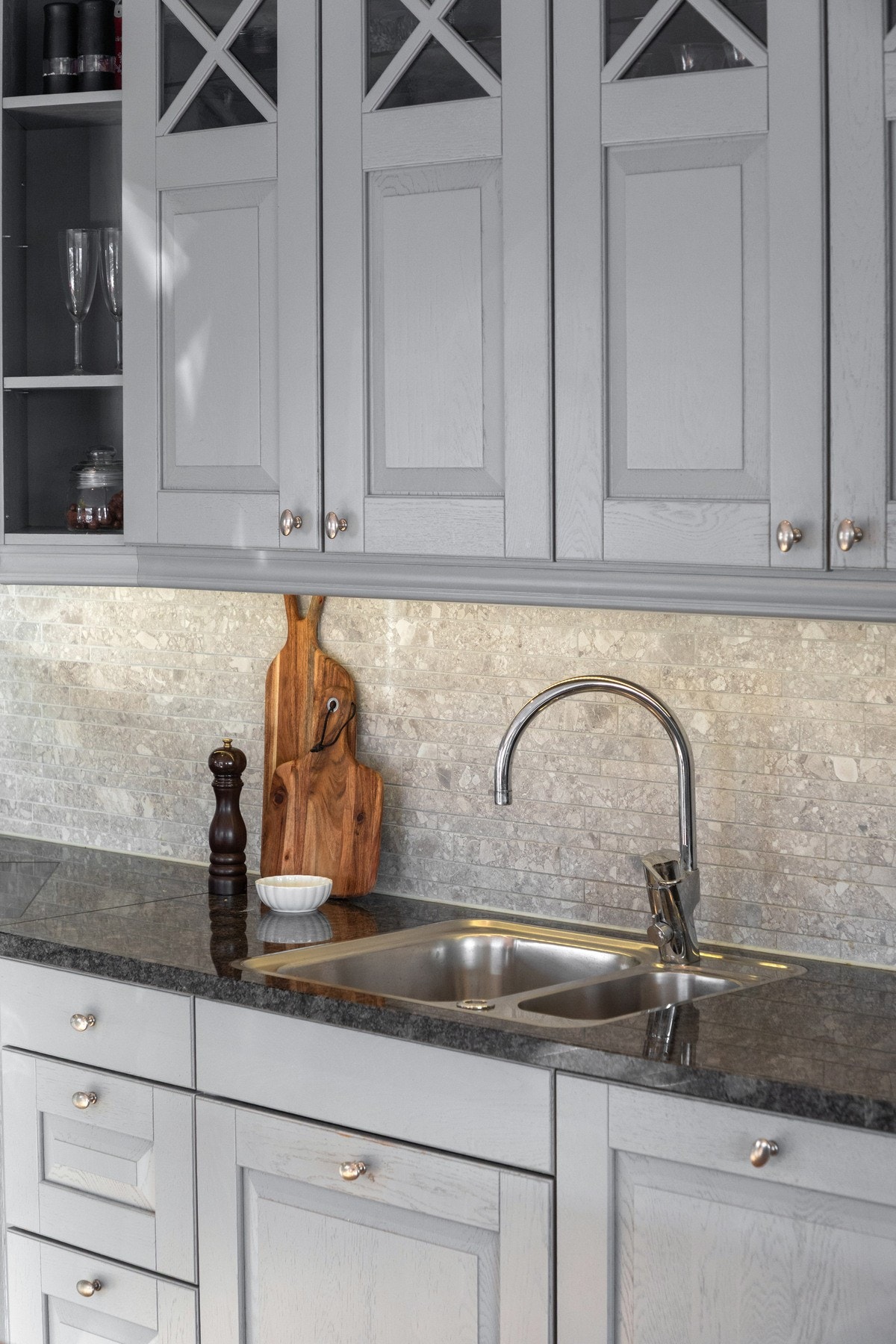 Over benkeplassen er det montert belysning og grå mosaikkfliser, og over kokesonen er det ventilator med avtrekk til det fri. Galleribilde