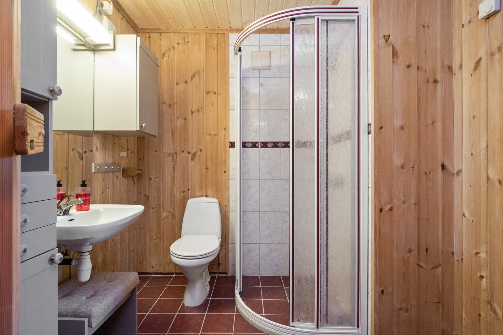 Innredningen består av enkel servant, to veggmonterte skap og speil med belysning over servanten. Galleribilde