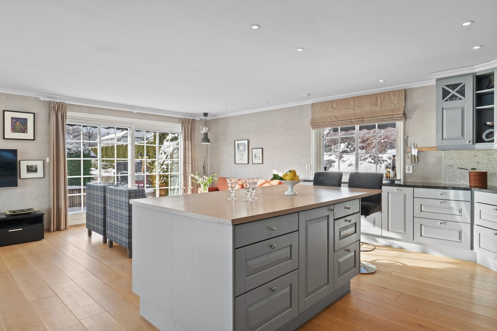 Kjøkkenet glir sømløst over i stuen og har en funksjonell L-form kombinert med en flott, sentralt plassert kjøkkenøy. Galleribilde