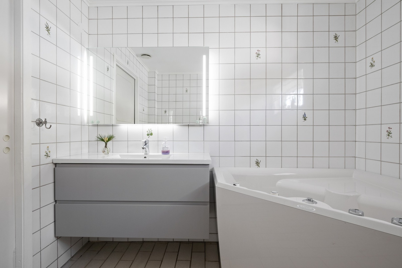 Innredningen består av servant med lysegrå skuffer og speil med integrert belysning. Galleribilde