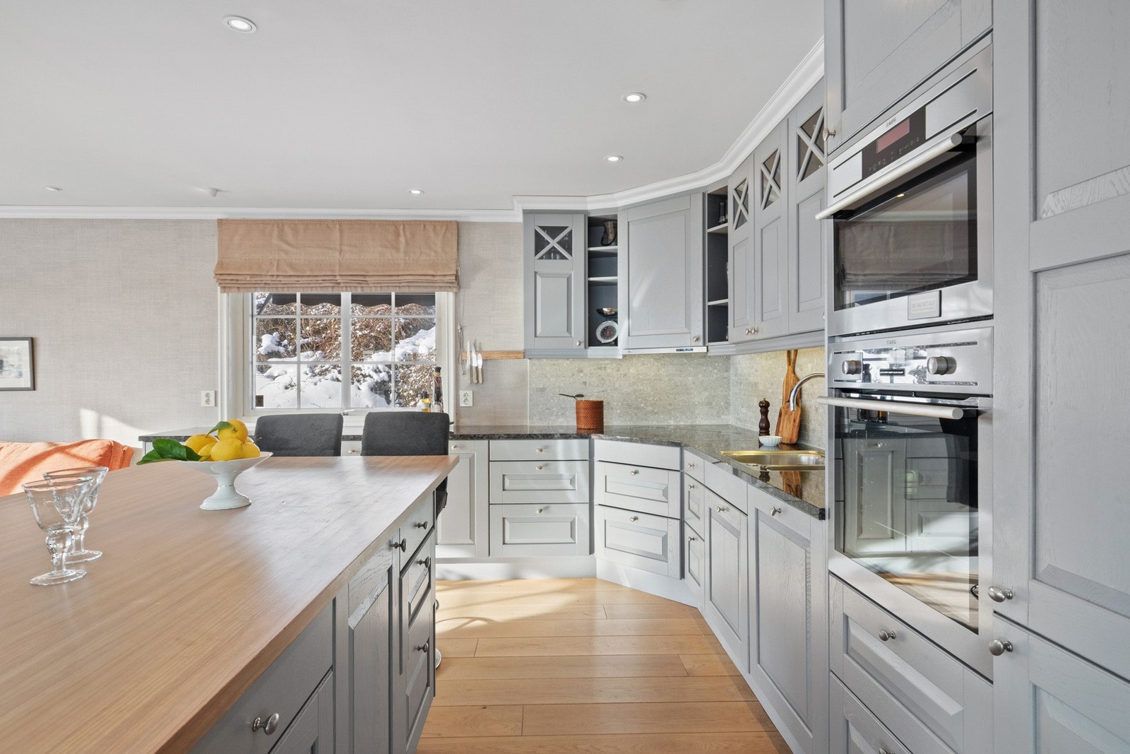 Romslig og familievennlig kjøkken med rikelig oppbevaringsplass, gode arbeidsflater og en praktisk barløsning på øya. Galleribilde