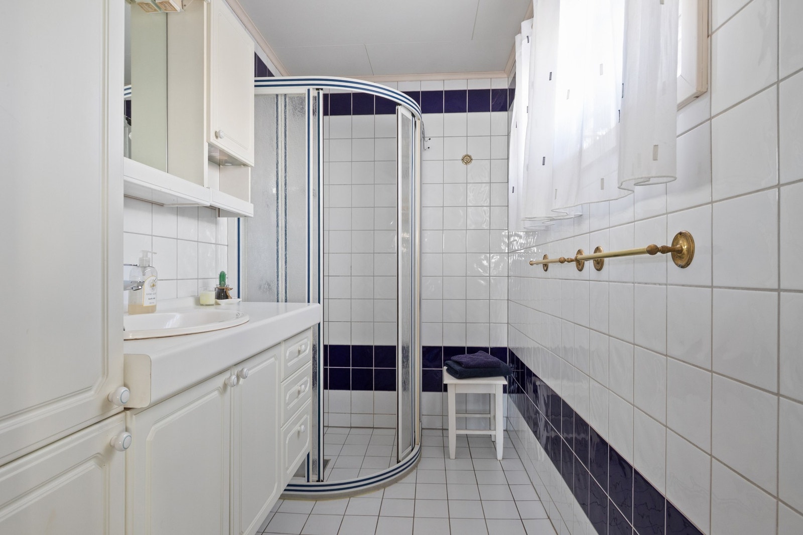 Badet er helfliset og utstyrt med varmekabler samt dusjhjørne med skyvedører. Galleribilde