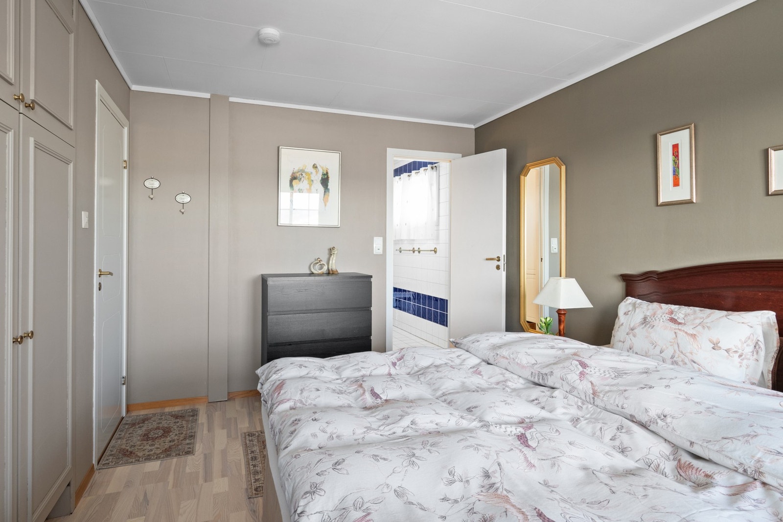 Rommet ble pusset opp i 2024 med nytt parkettgulv og nymalte vegger. Fargepaletten går i delikate gråtoner, og rommet har innebygd garderobeskap med profilerte fronter. Galleribilde