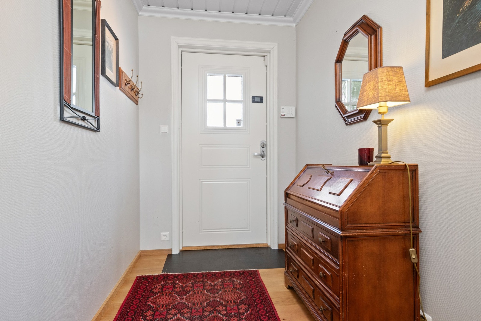 Entré med lysegrå vegger og 1-stavs parkettgulv. Galleribilde