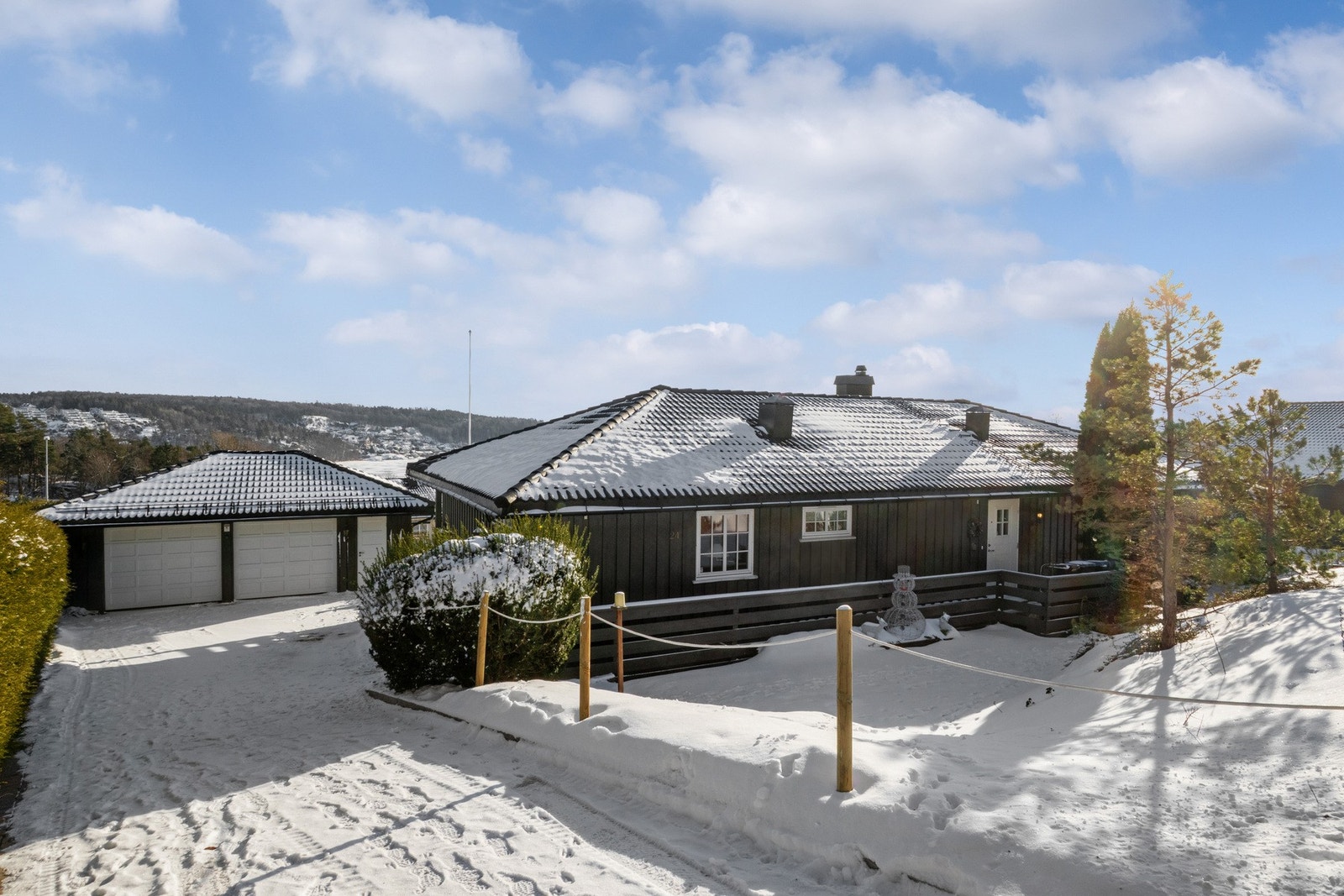 Adkomsten skjer via steinlagt nedkjørsel med avløpsrenne nederst for effektiv oppsamling og bortledning av overvann. Galleribilde