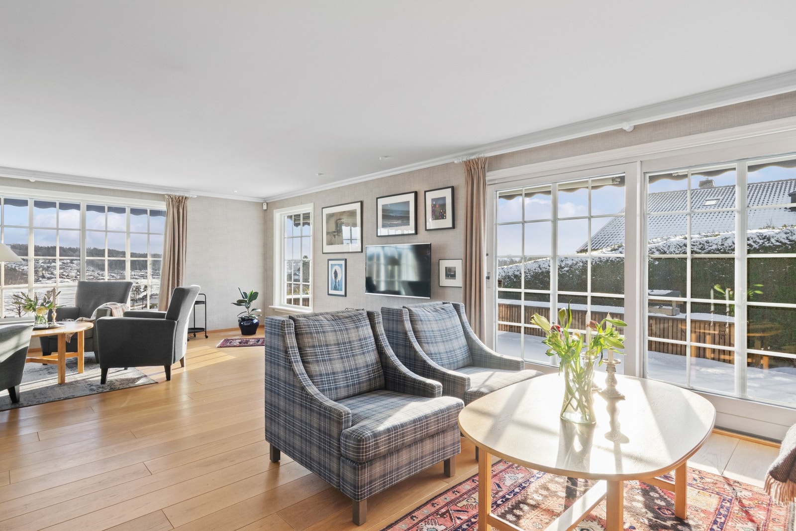 En skyvedør leder ut til terrassen, og i sommerhalvåret oppleves uteplassen som en naturlig forlengelse av stuen. Galleribilde