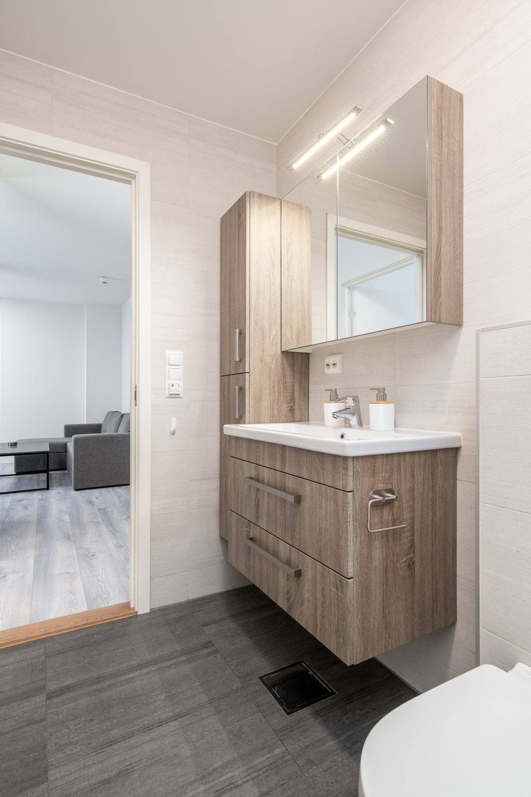 Pent og flislagt bad med moderne innredning og plass til vaskemaskin Galleribilde