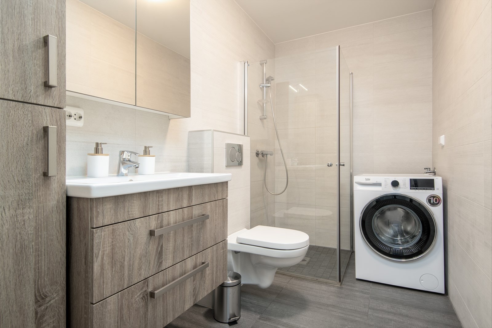 Pent og flislagt bad med moderne innredning og plass til vaskemaskin Galleribilde