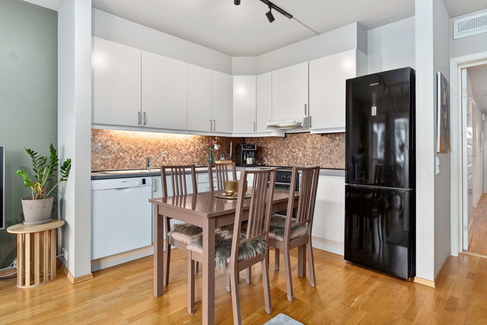 Godt utnyttet og tidløst kjøkken med hvite fronter og laminert benkeplate. Det er parkett på gulv og plass til spisebord. Galleribilde