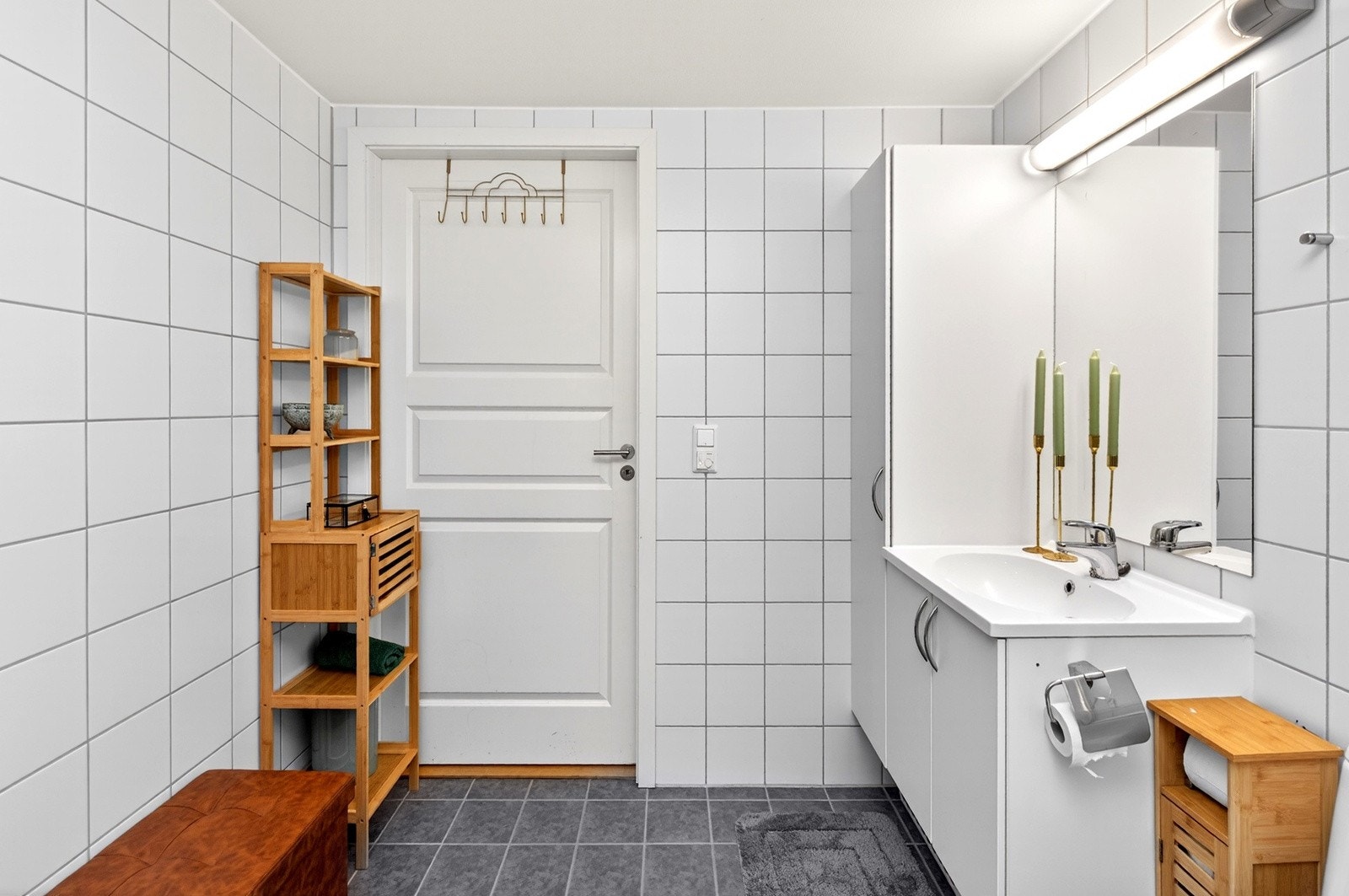 Innredning med skapløsning, speil med oveliggende lys og høyskap gir godt med plass for oppbevaring av hådtklær og baderomsartikler. Galleribilde